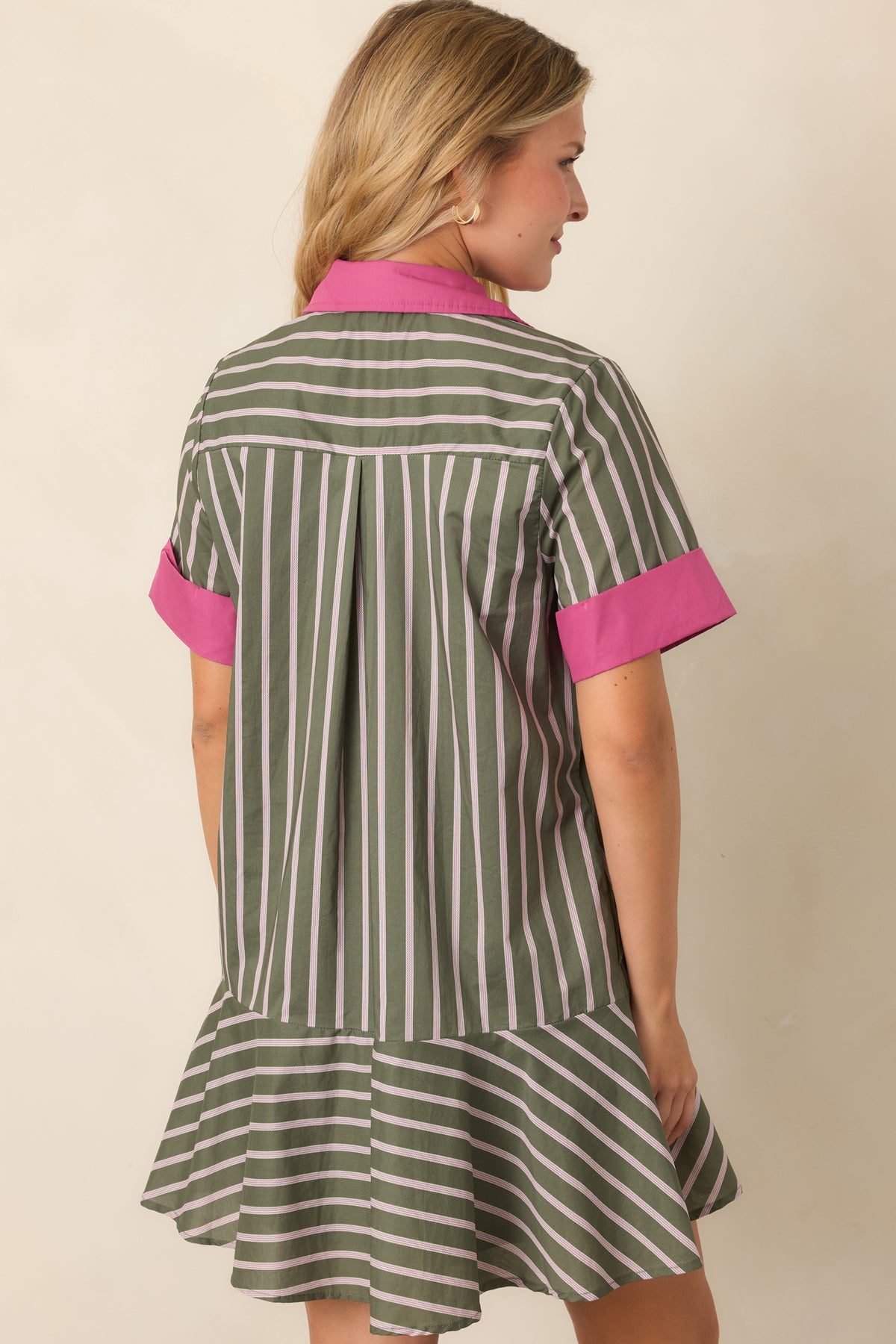 Rear of the olive striped mini dress showing the back pleat, relaxed silhouette, short sleeves, and contrasting stripe placement at the flounce hem.