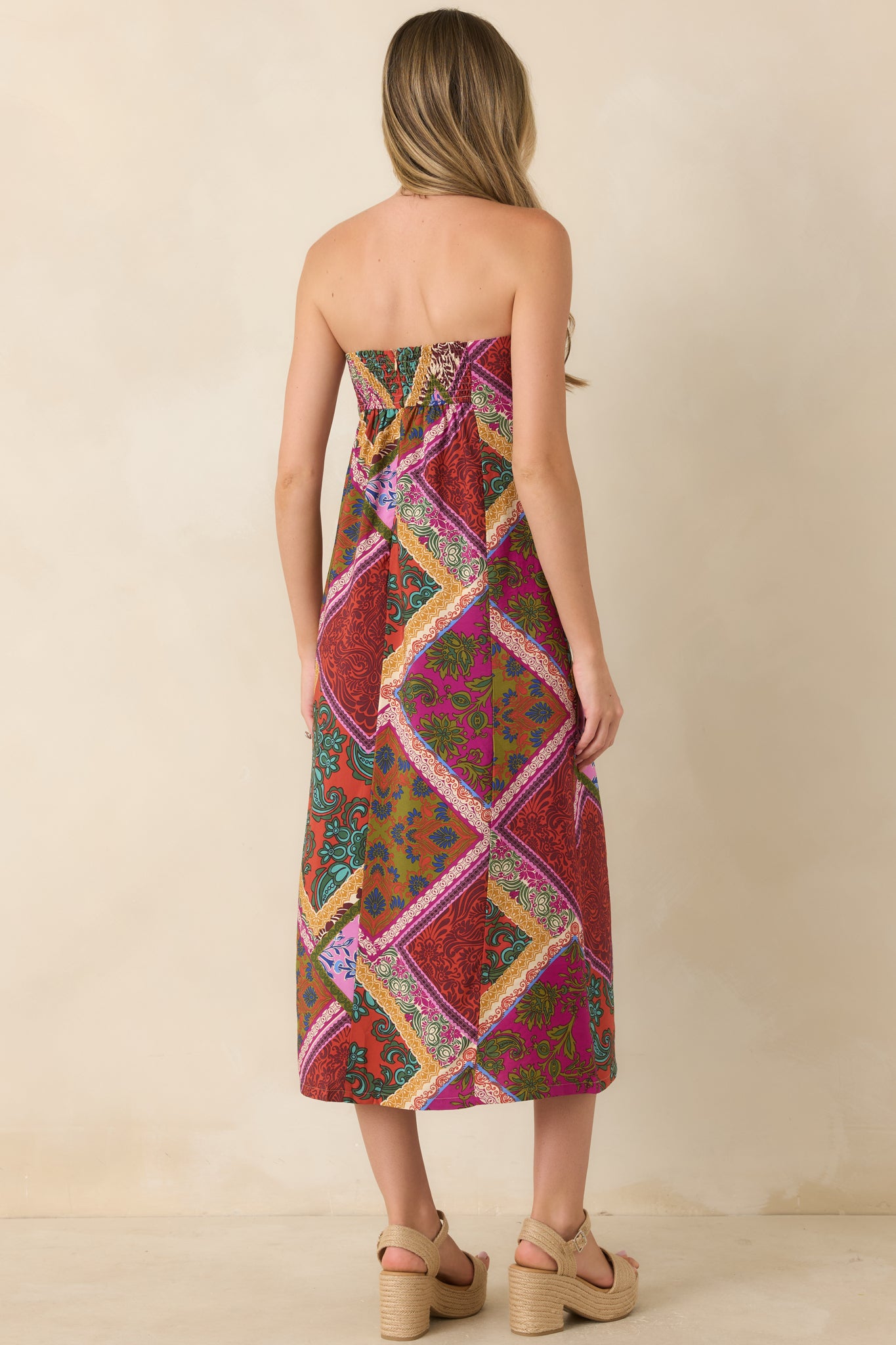 Rear view of the red multi patchwork midi dress featuring a smocked back panel and hidden zipper for a comfortable fit.