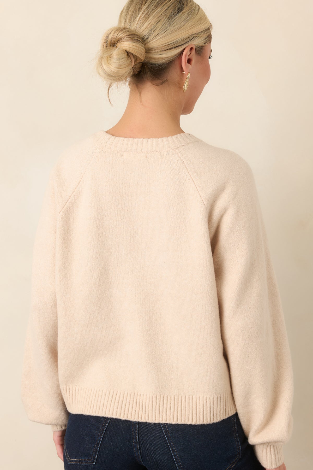 Rear of the top showing the raglan sleeve seams, softly gathered sleeves, and ribbed hem.