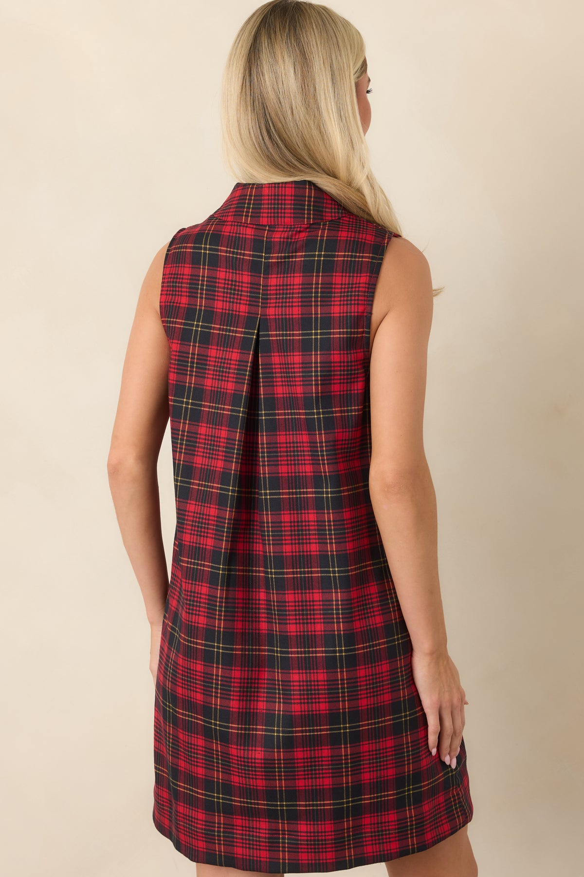 Rear view of the red and black plaid mini dress showing the back pleat and relaxed shift silhouette.