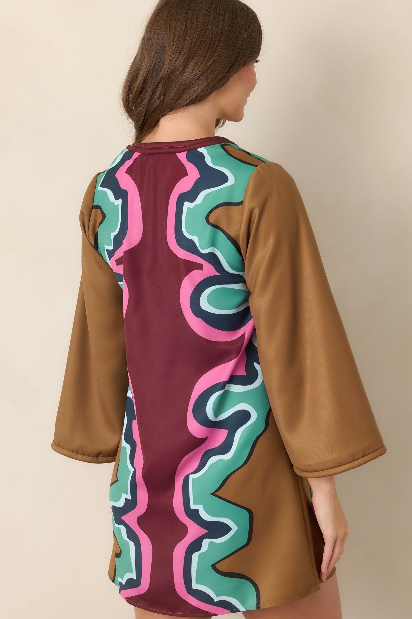 Rear view of the Serpentine-print mini dress showcasing its relaxed A-line silhouette, wide three-quarter sleeves, and colorful structured poly twill fabric.