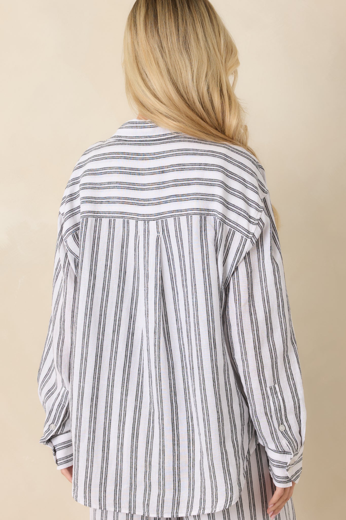 Black and white striped top with relaxed rear silhouette and long sleeve design.

