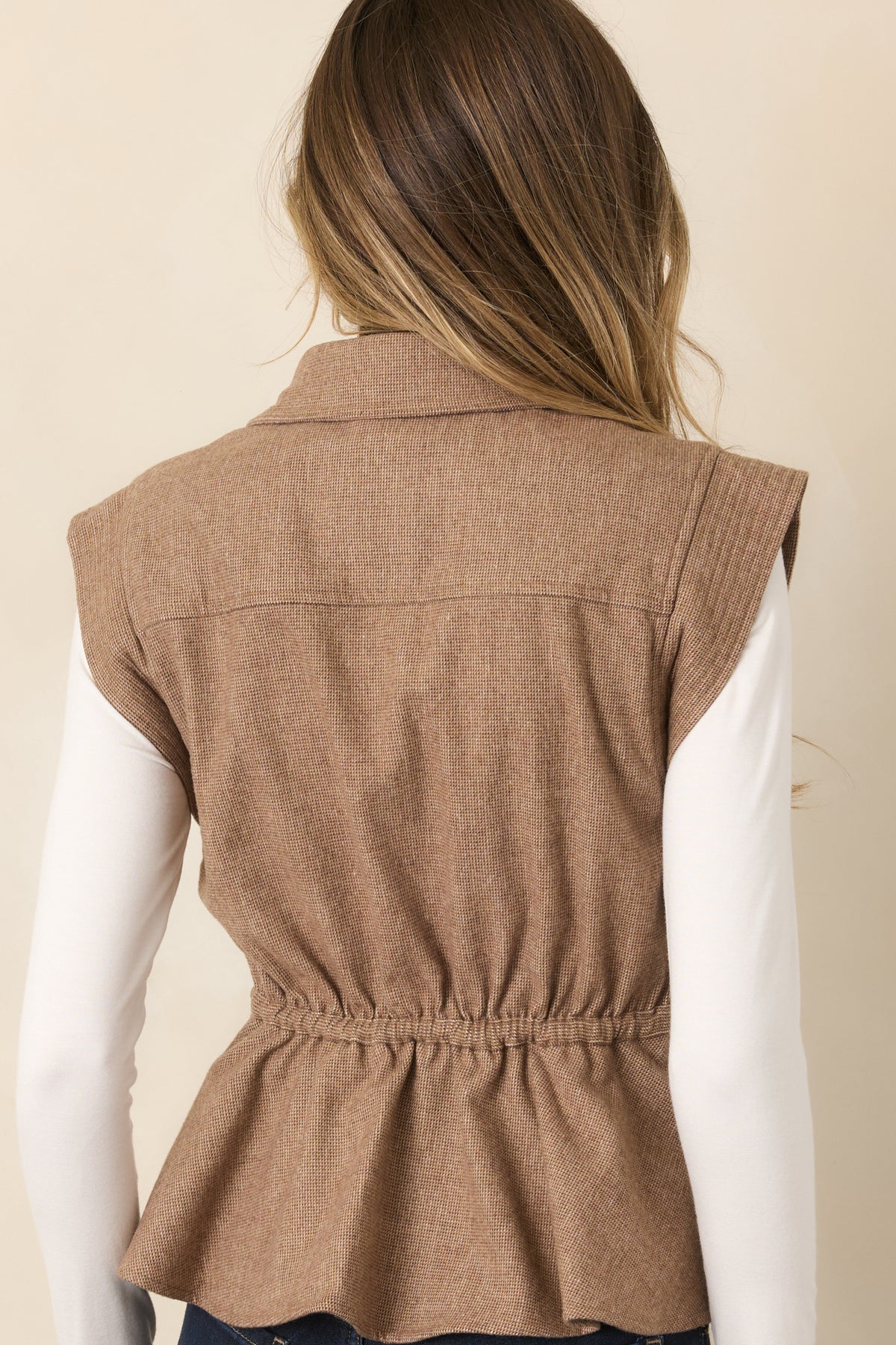 Rear of the sleeveless wool-blend vest showing the adjustable drawstring waist, wide shoulders, and flared hem.