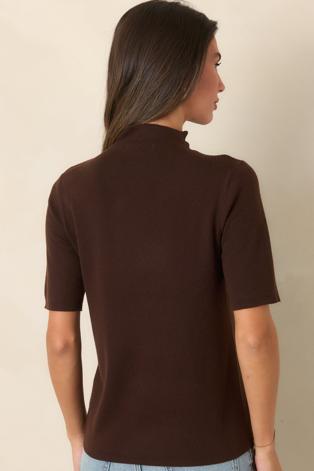 Rear view of the soft knit top showcasing the high neckline and short sleeves.