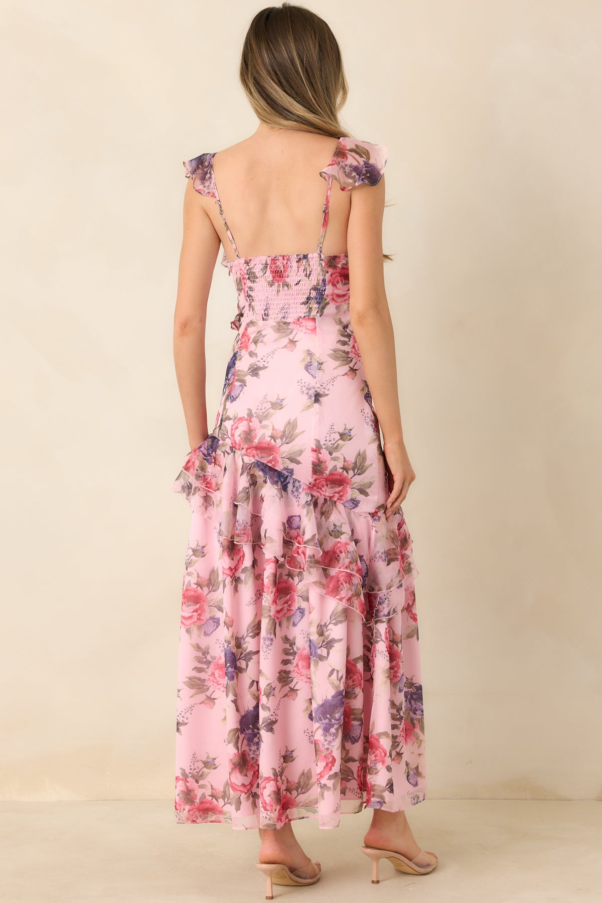 Rear of the soft pink floral maxi dress featuring a smocked back bodice and flowing skirt with scattered blooms.