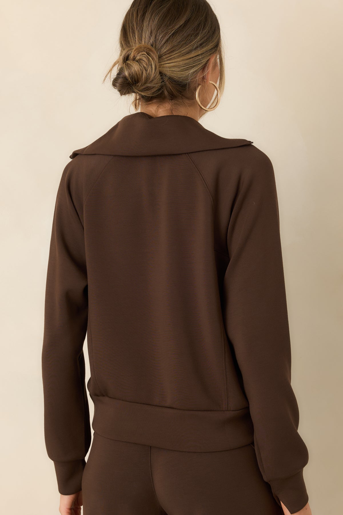 Rear of the spacer fabric pullover featuring a smooth back, long sleeves, and a wide banded hem.
