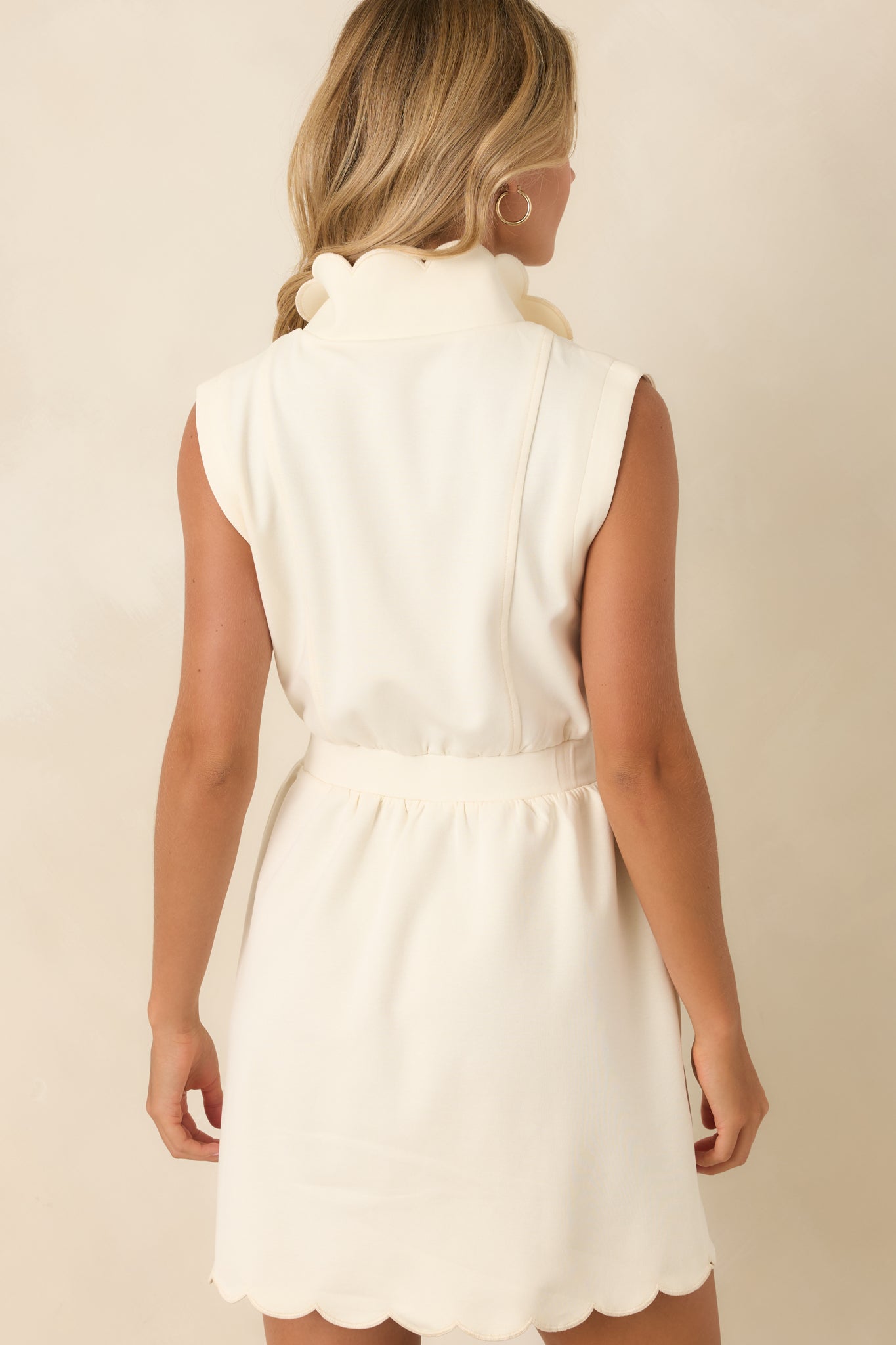 Rear view of the structured sleeveless mini dress showcasing cap-style shoulders and a tailored silhouette.