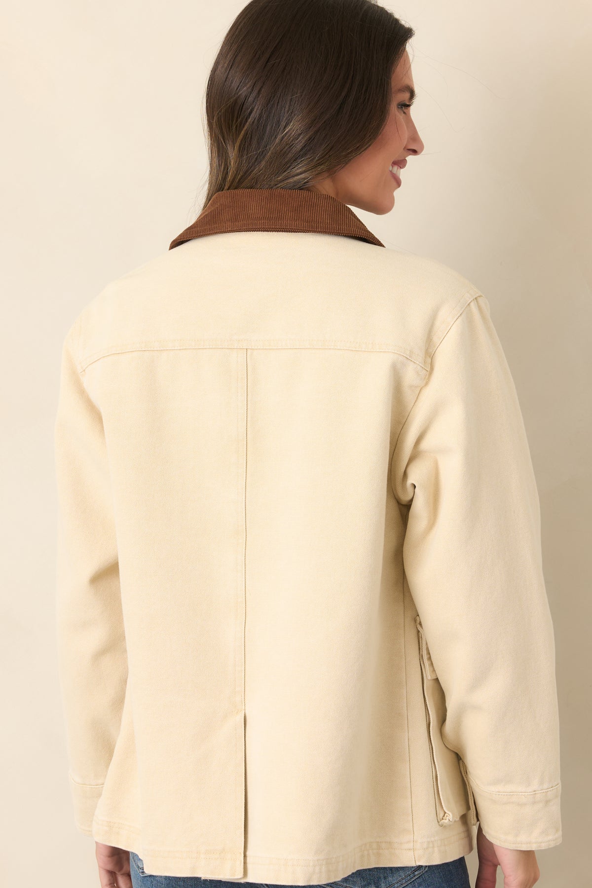 Rear of the taupe cotton canvas utility jacket showcasing its relaxed straight silhouette, long sleeves, and clean back panel.