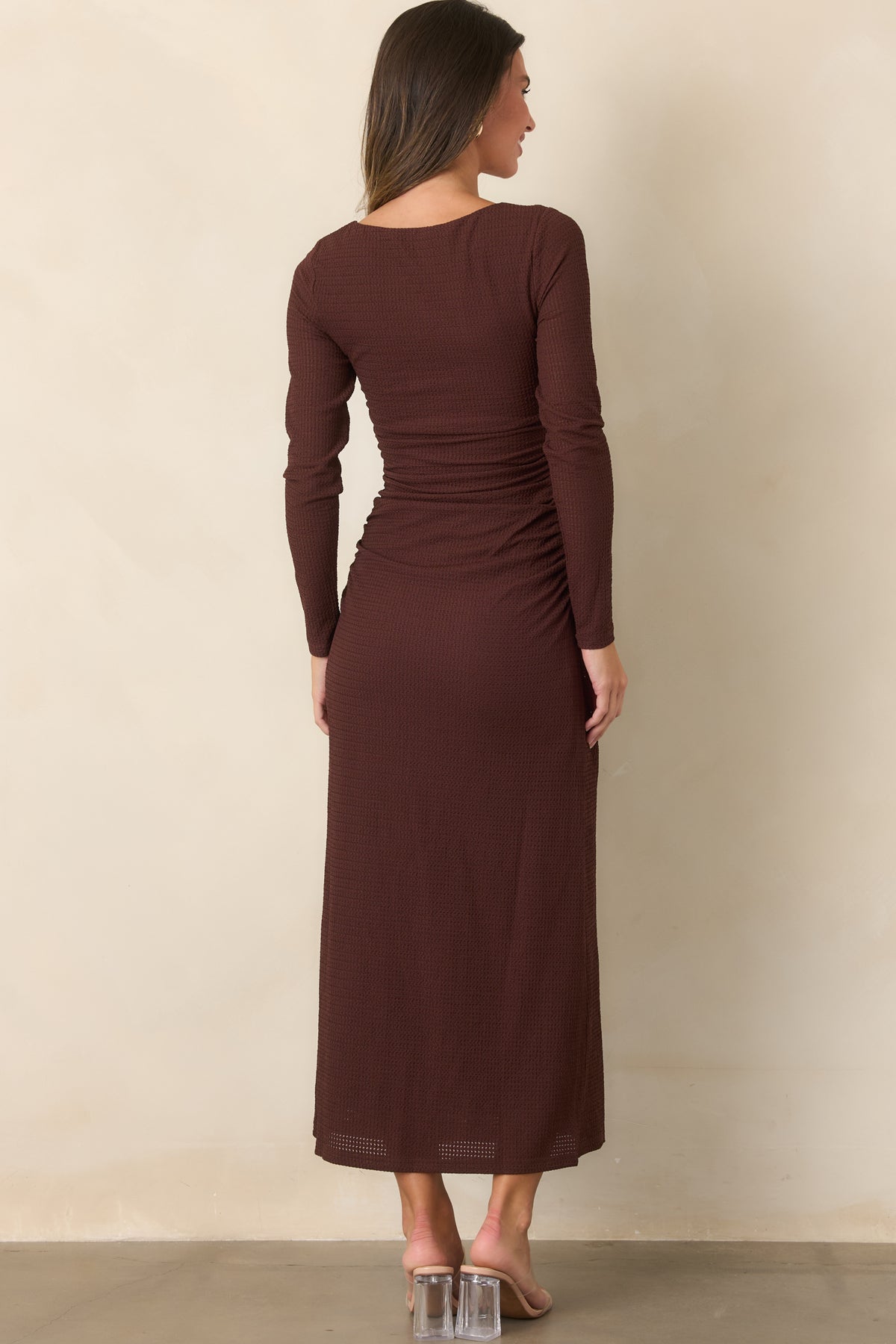 Rear view shows the textured fabric, long sleeves, curve-skimming waist, and softly flowing midi skirt.