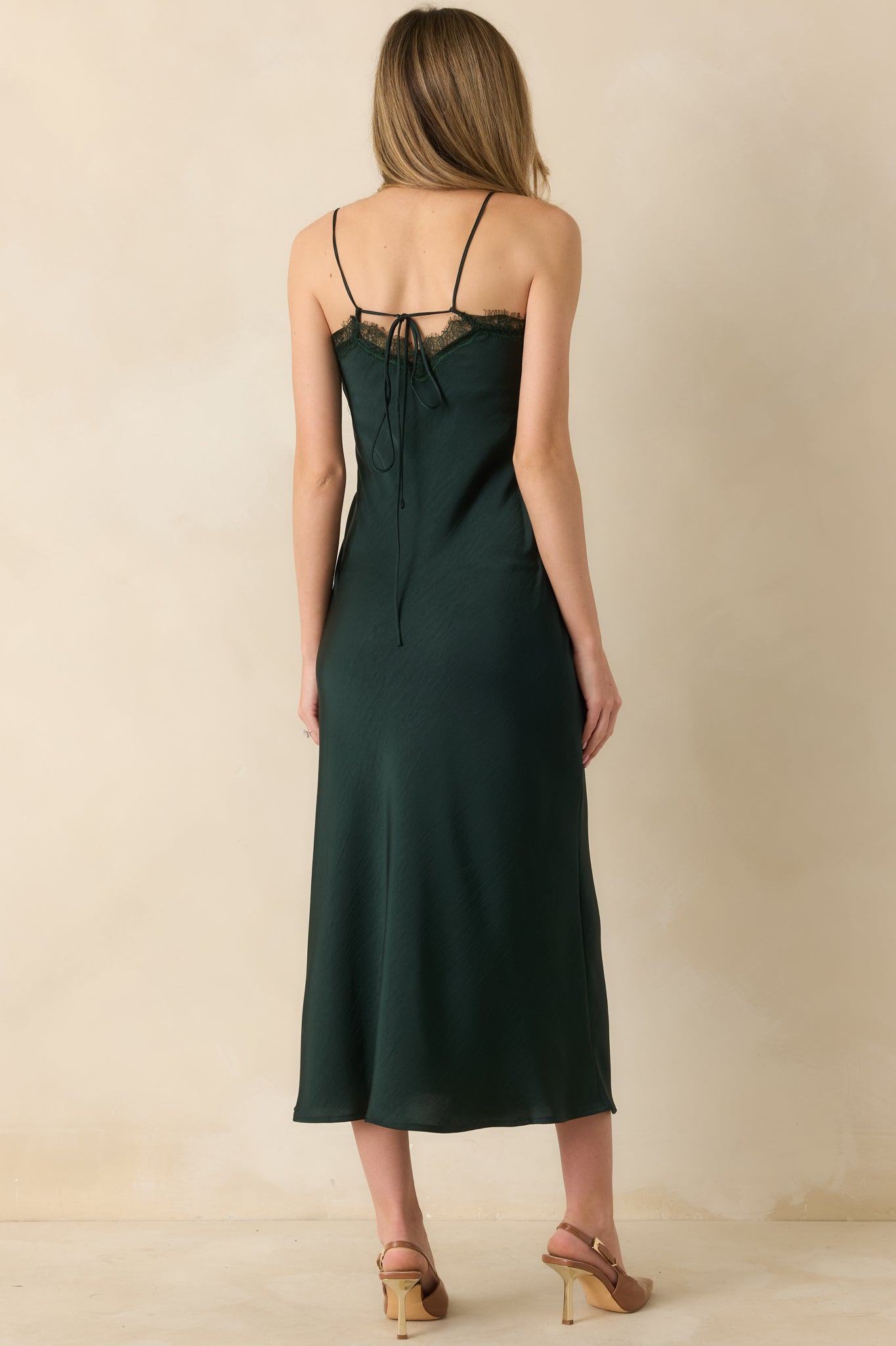 Back view highlighting the tie-back detail, spaghetti straps, and straight midi-length hem.