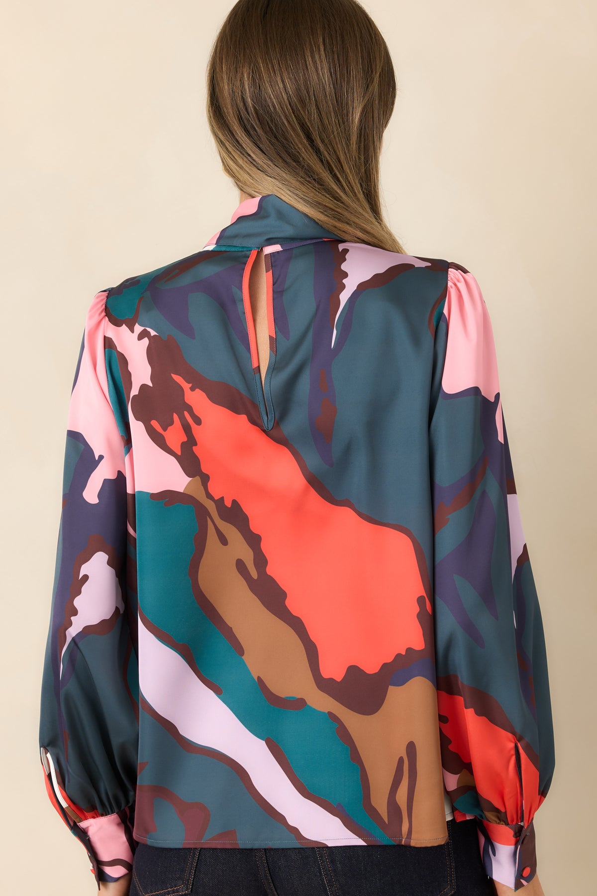 Rear view of the abstract print blouse featuring a back keyhole and long sleeves.