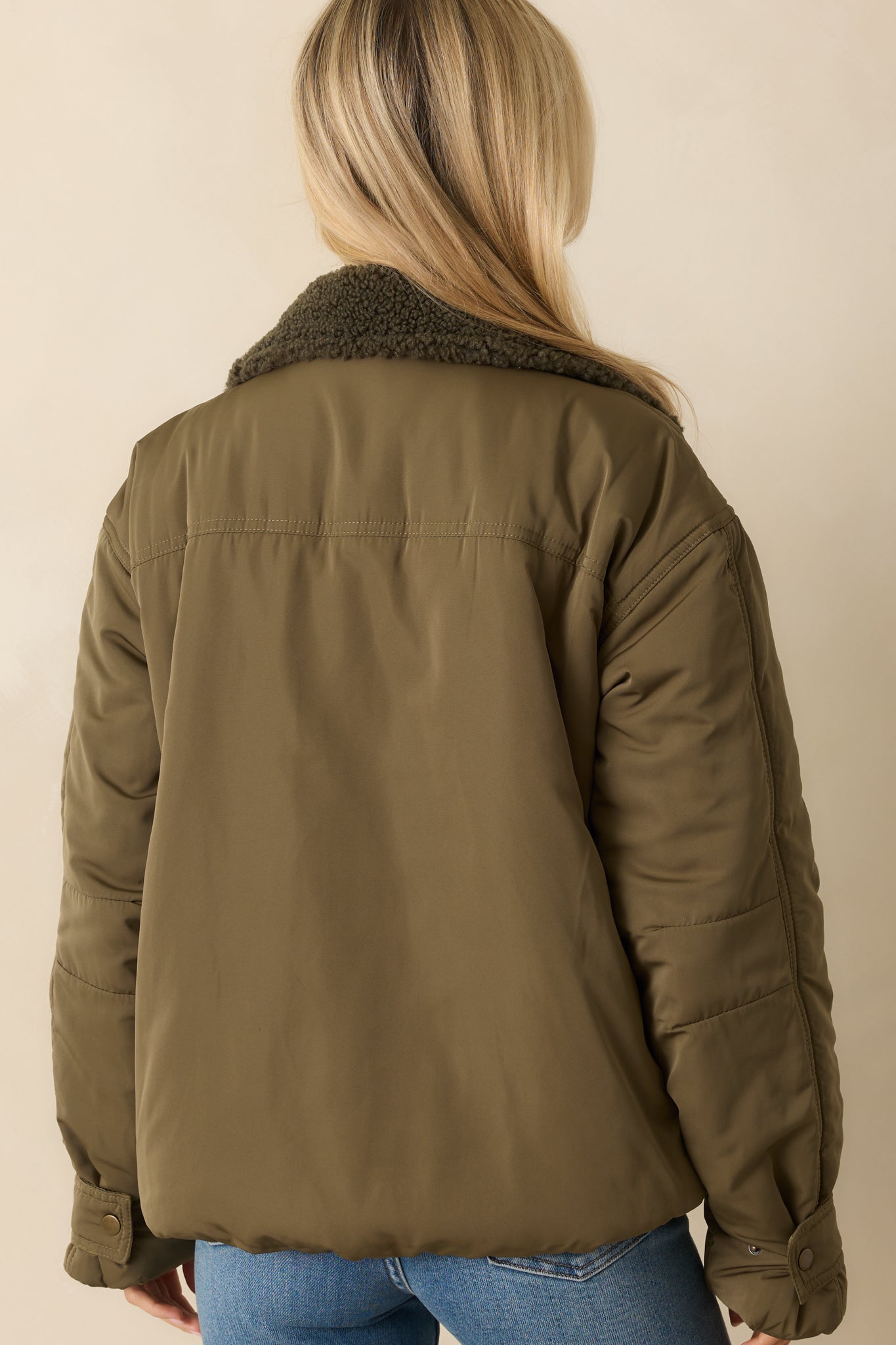 Rear view of the army green puffer jacket showing the smooth back and relaxed boxy silhouette.