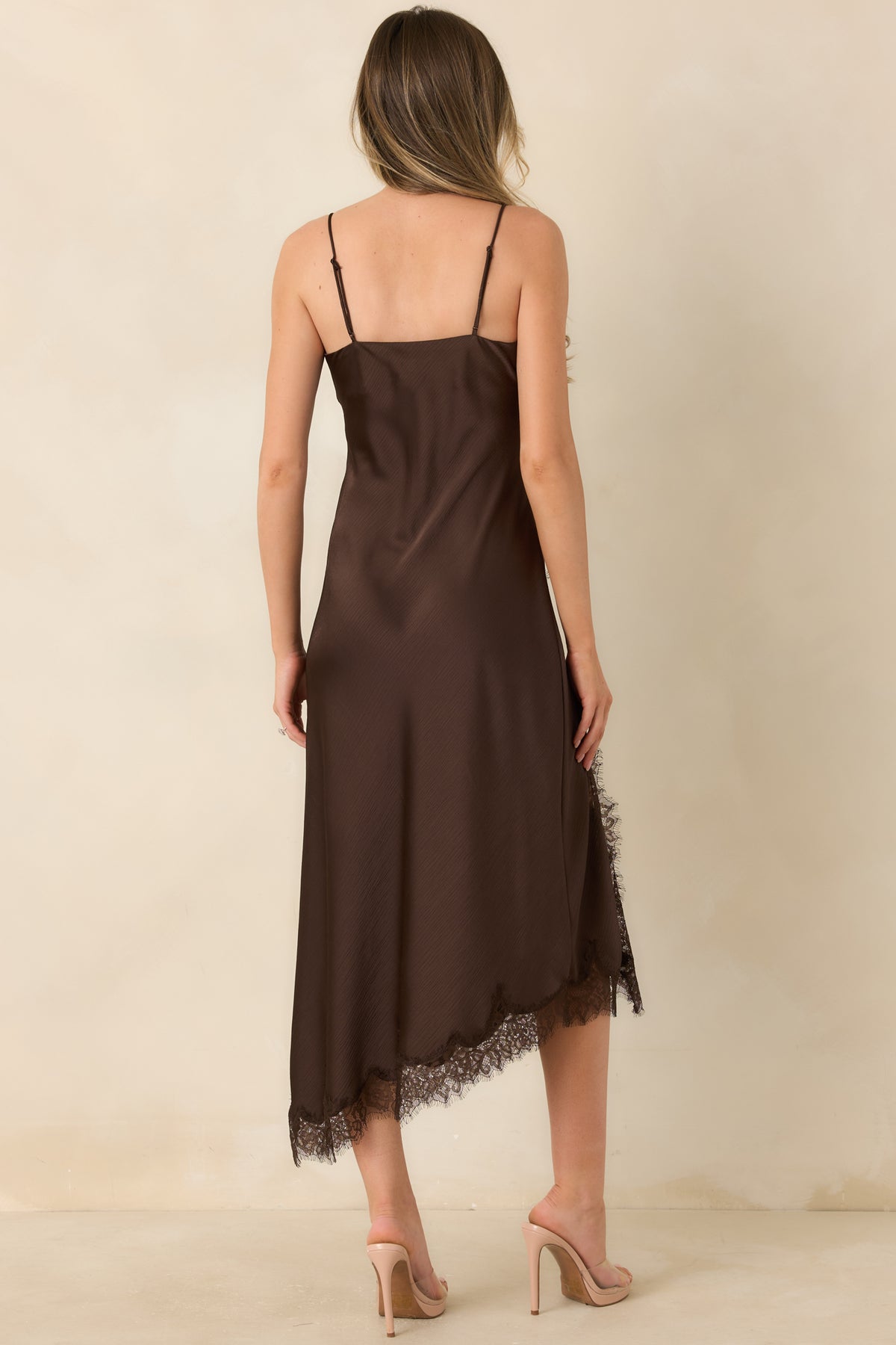 Rear view of the bias-cut satin midi dress with thin adjustable straps and a flowing hem.