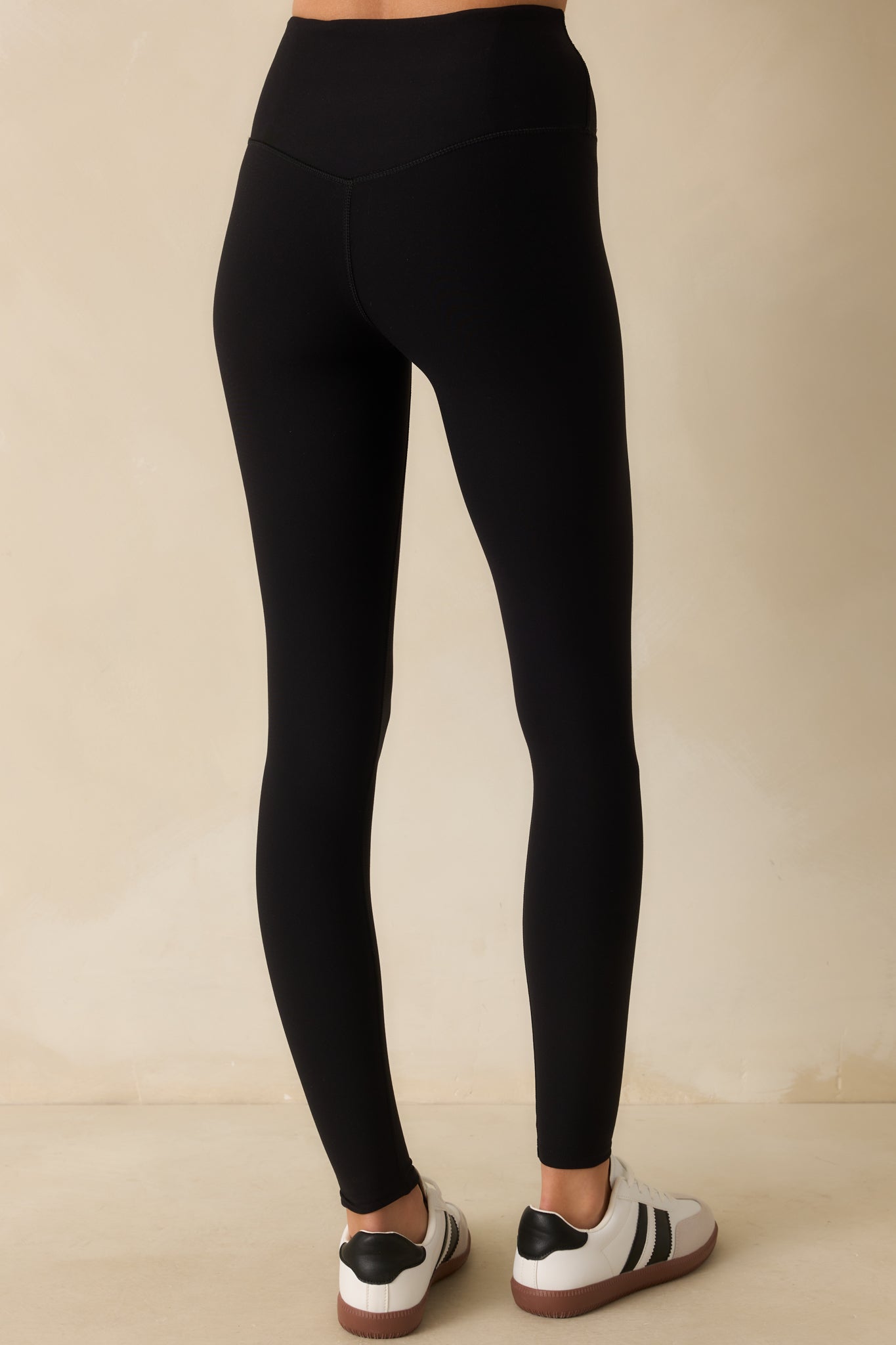 Rear view of the black leggings showing the flattering back detail and center-seam-free design.