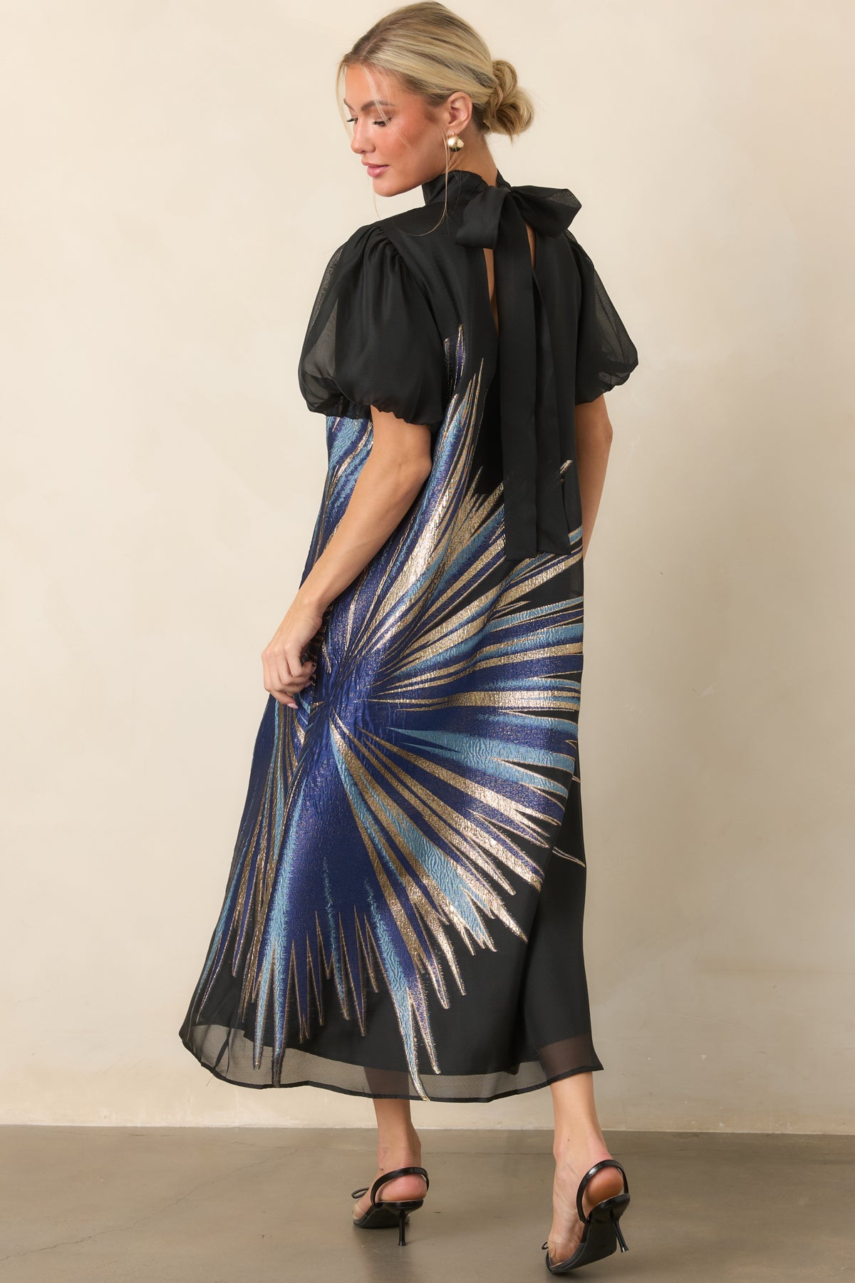 Rear view of the black midi dress showing the high neckline, back keyhole, and long statement ties.