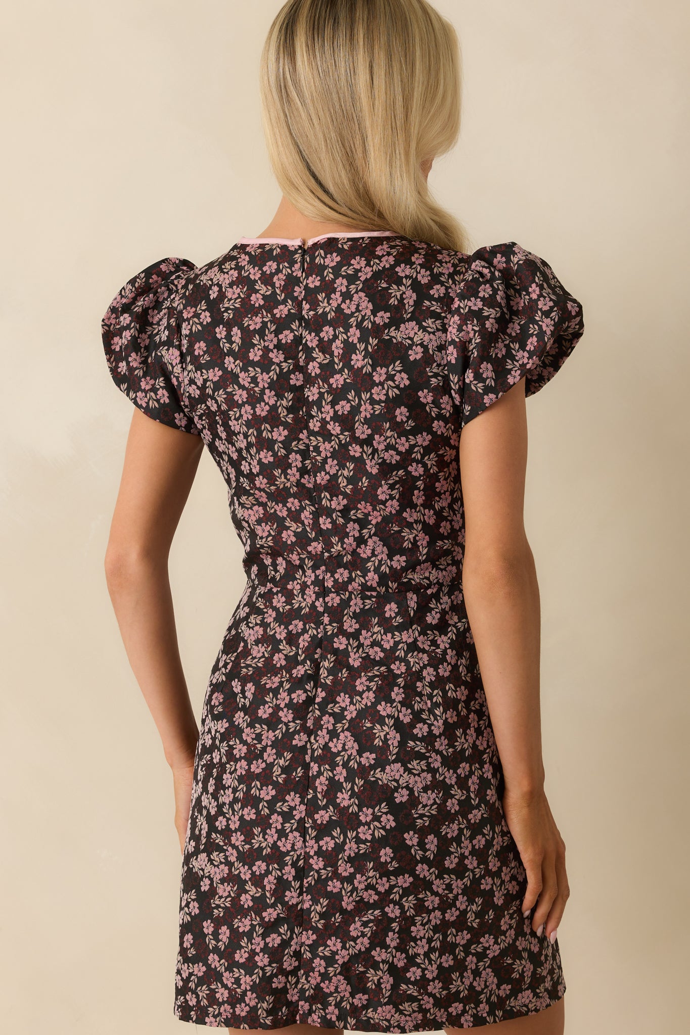 Rear view of the black mini dress showing the hidden back zipper and fitted silhouette.