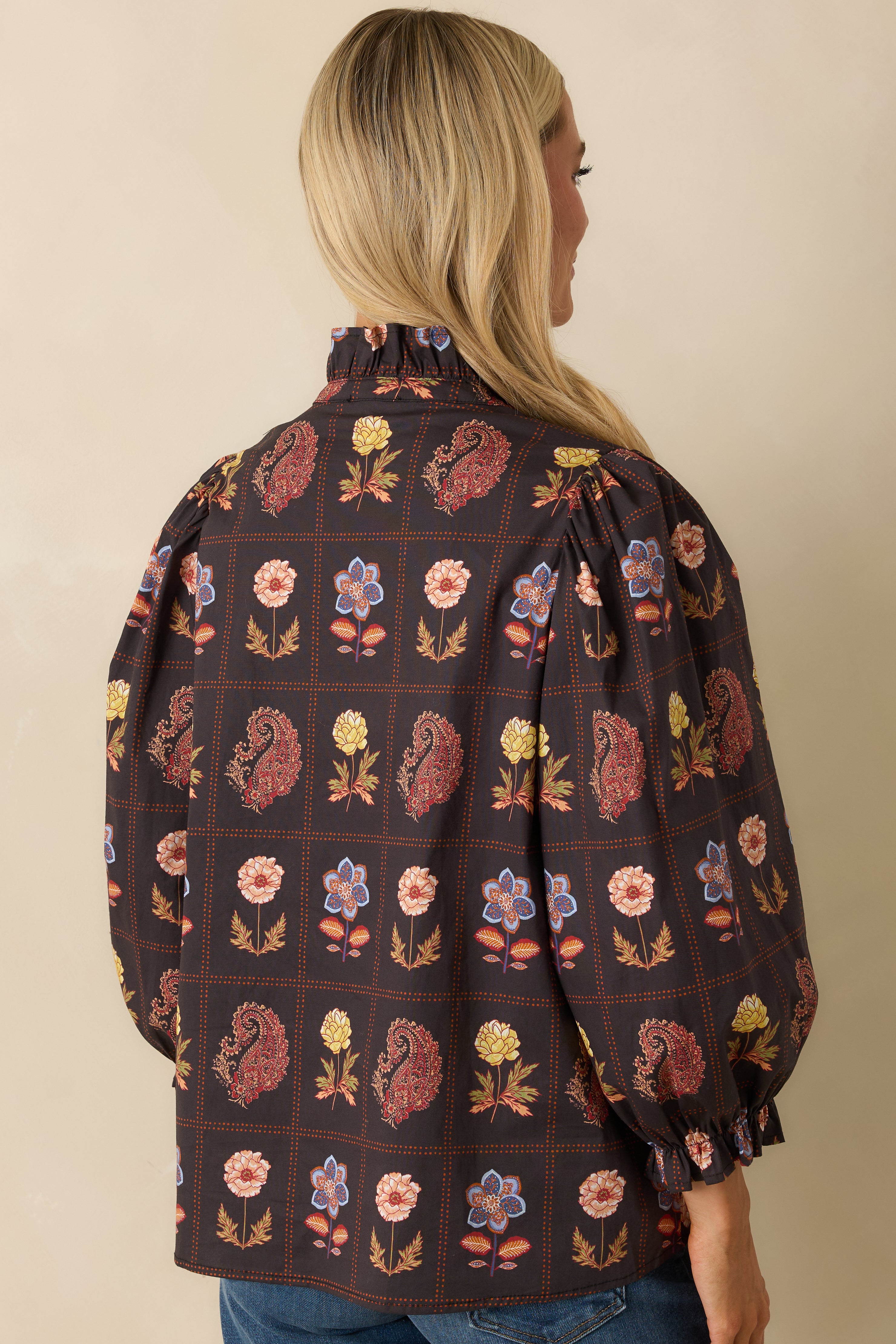 Rear view of the black multi floral blouse showing puff sleeves, ruffled cuffs, and relaxed fit.