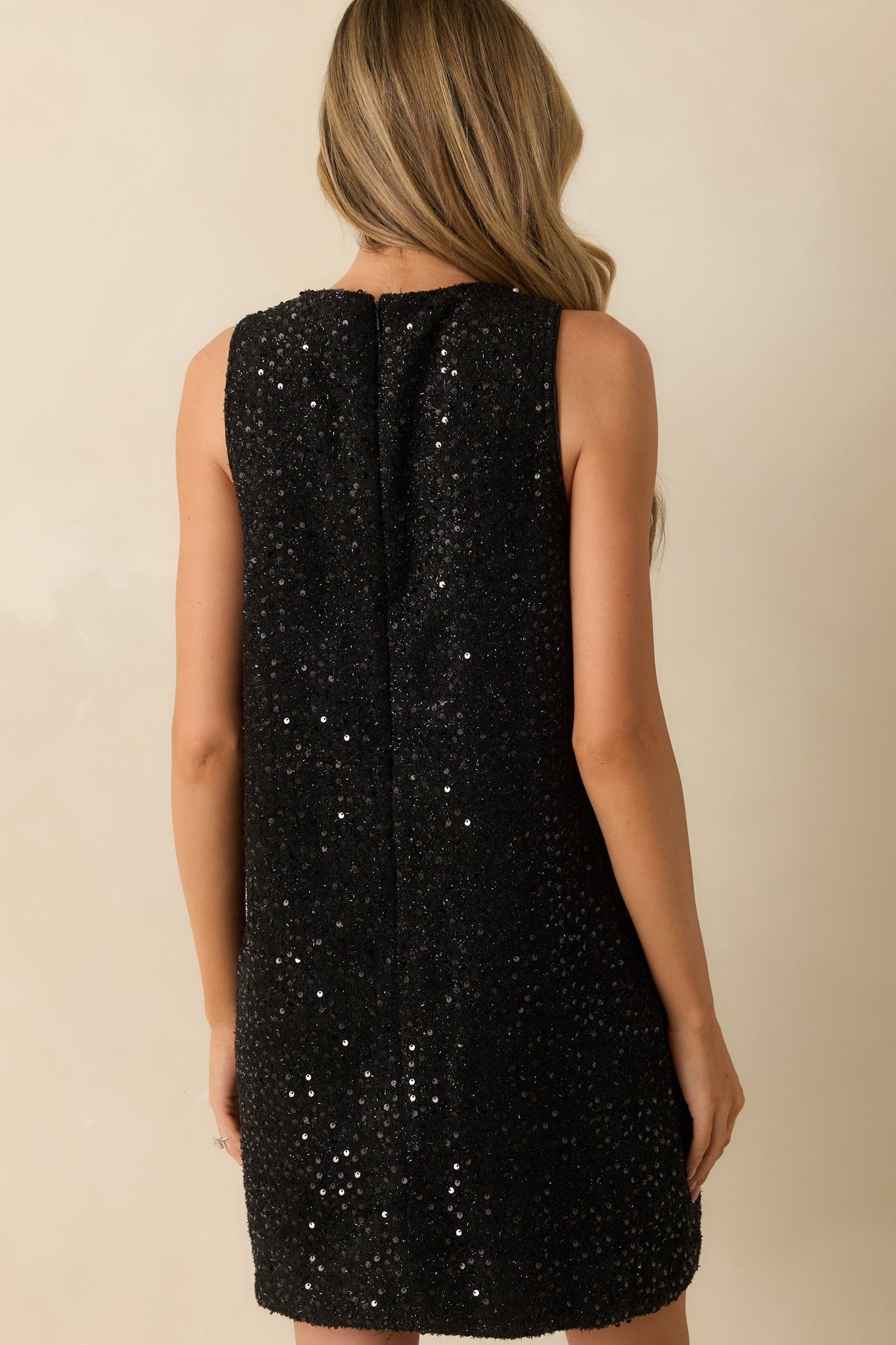 Rear view of the black sequin mini dress highlighting the back zipper closure and fully lined shift-style silhouette.
