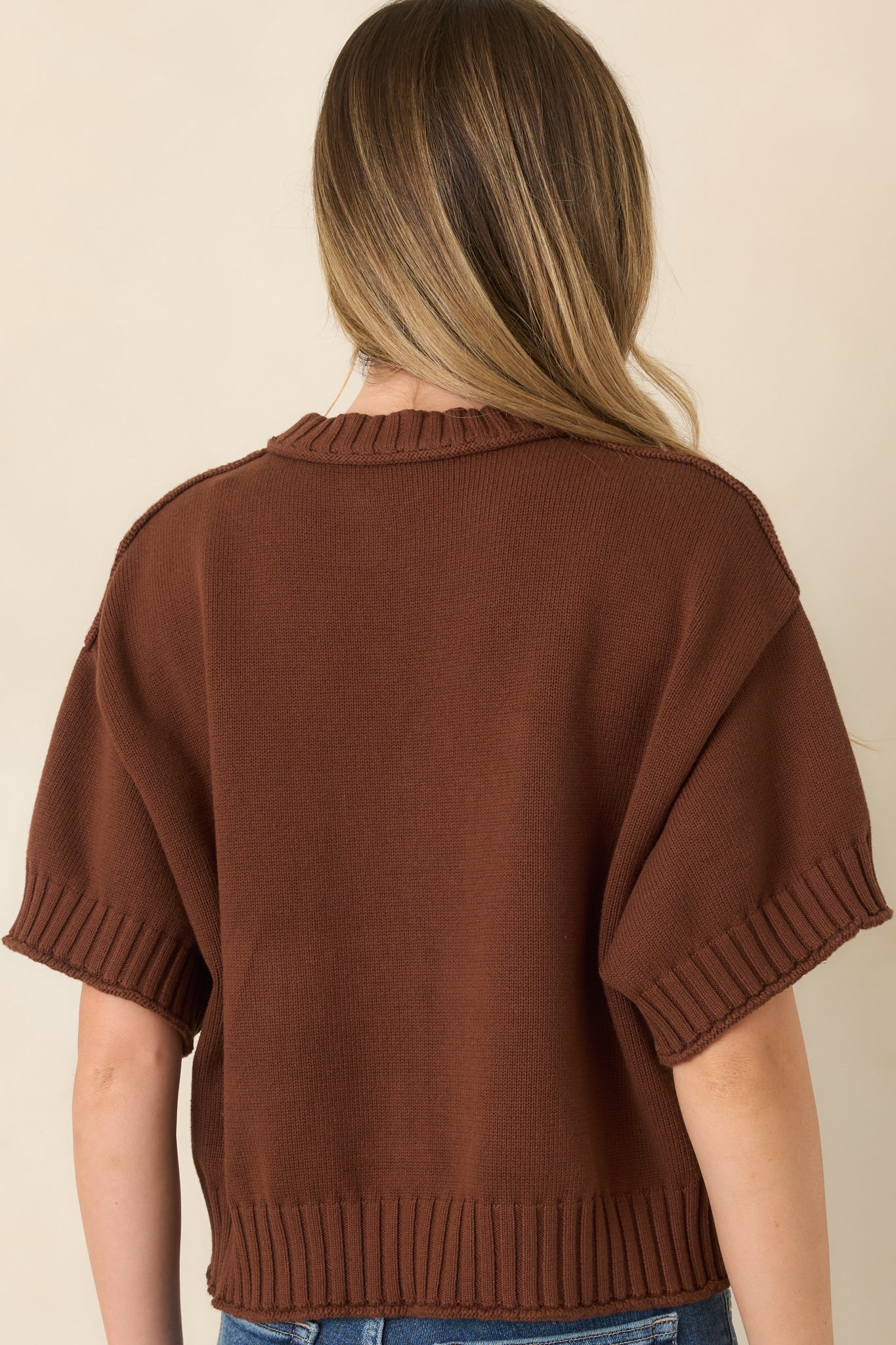 Rear view of the cotton top showcasing its relaxed boxy silhouette, short sleeves, and chunky ribbed hem and neckline.