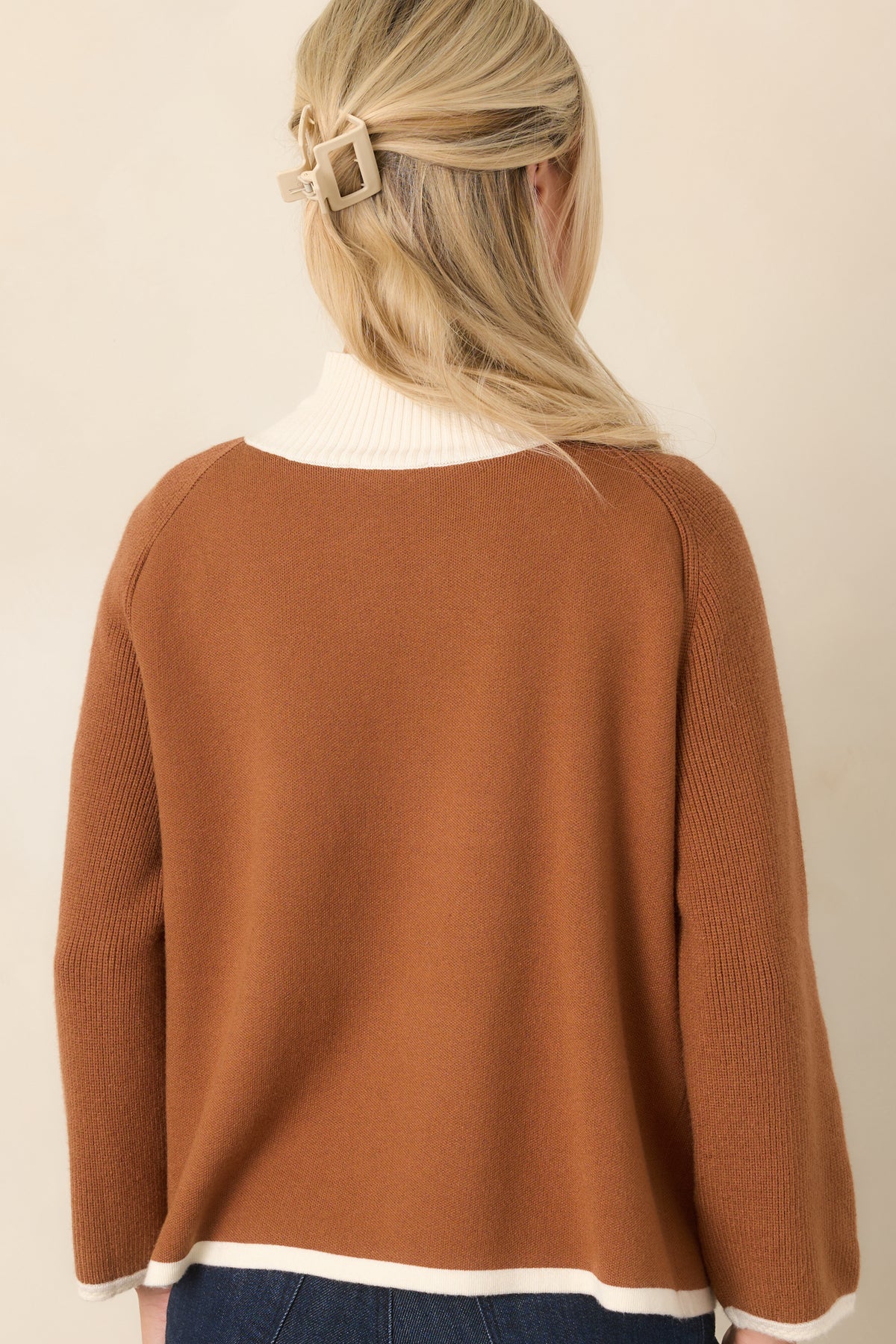 Rear view of the brown knit cardigan showing the relaxed silhouette, ribbed hem, and ivory contrast trim.