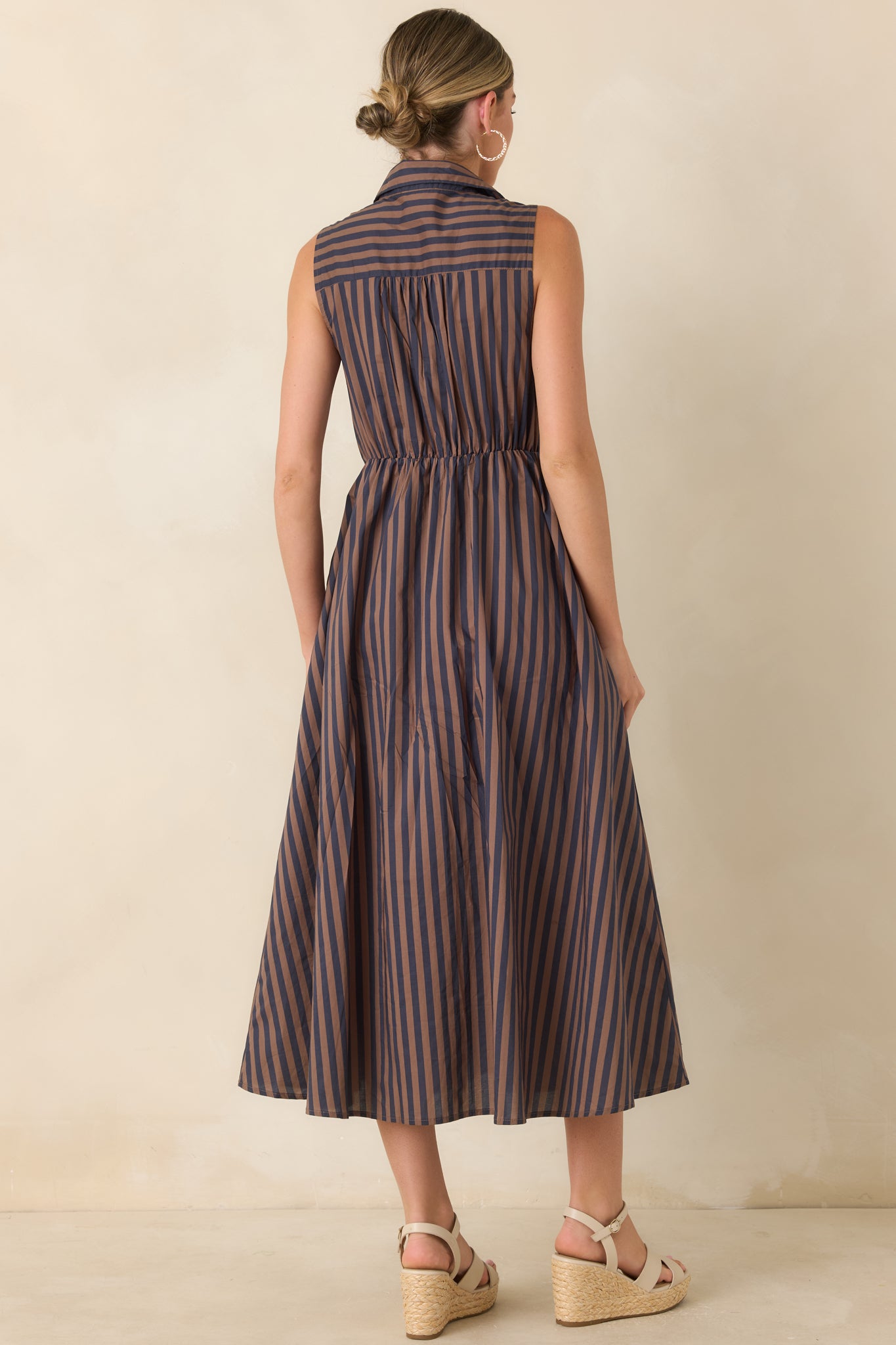 Rear view of the brown and navy striped midi dress featuring the gathered elasticized waist and flowing A-line skirt.