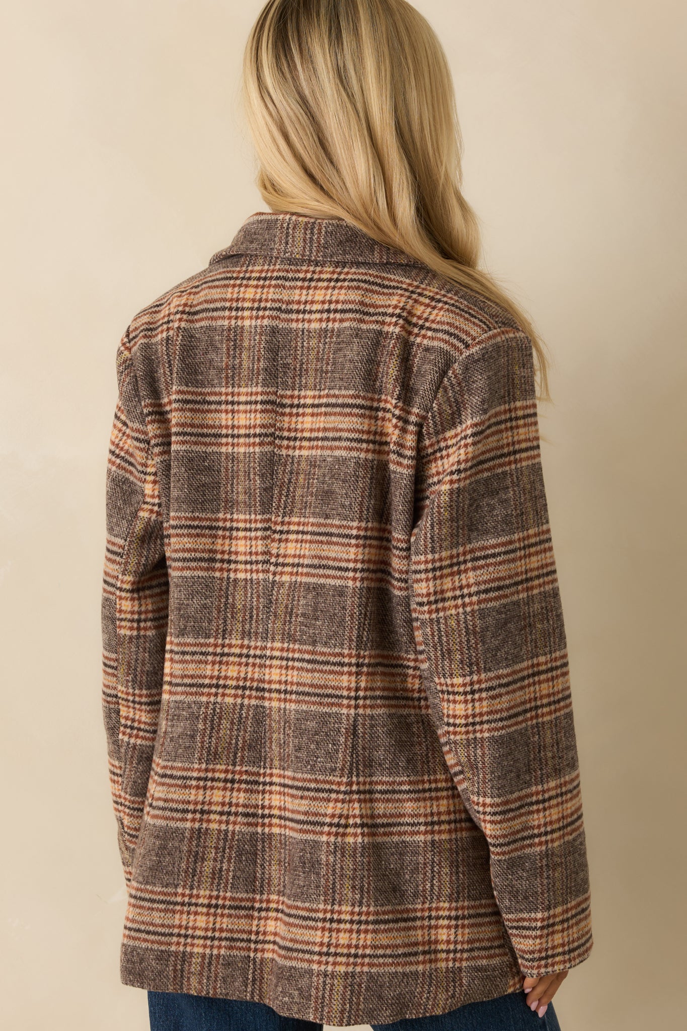Rear view of the brown plaid overcoat, showing the mid-length silhouette and long sleeves.