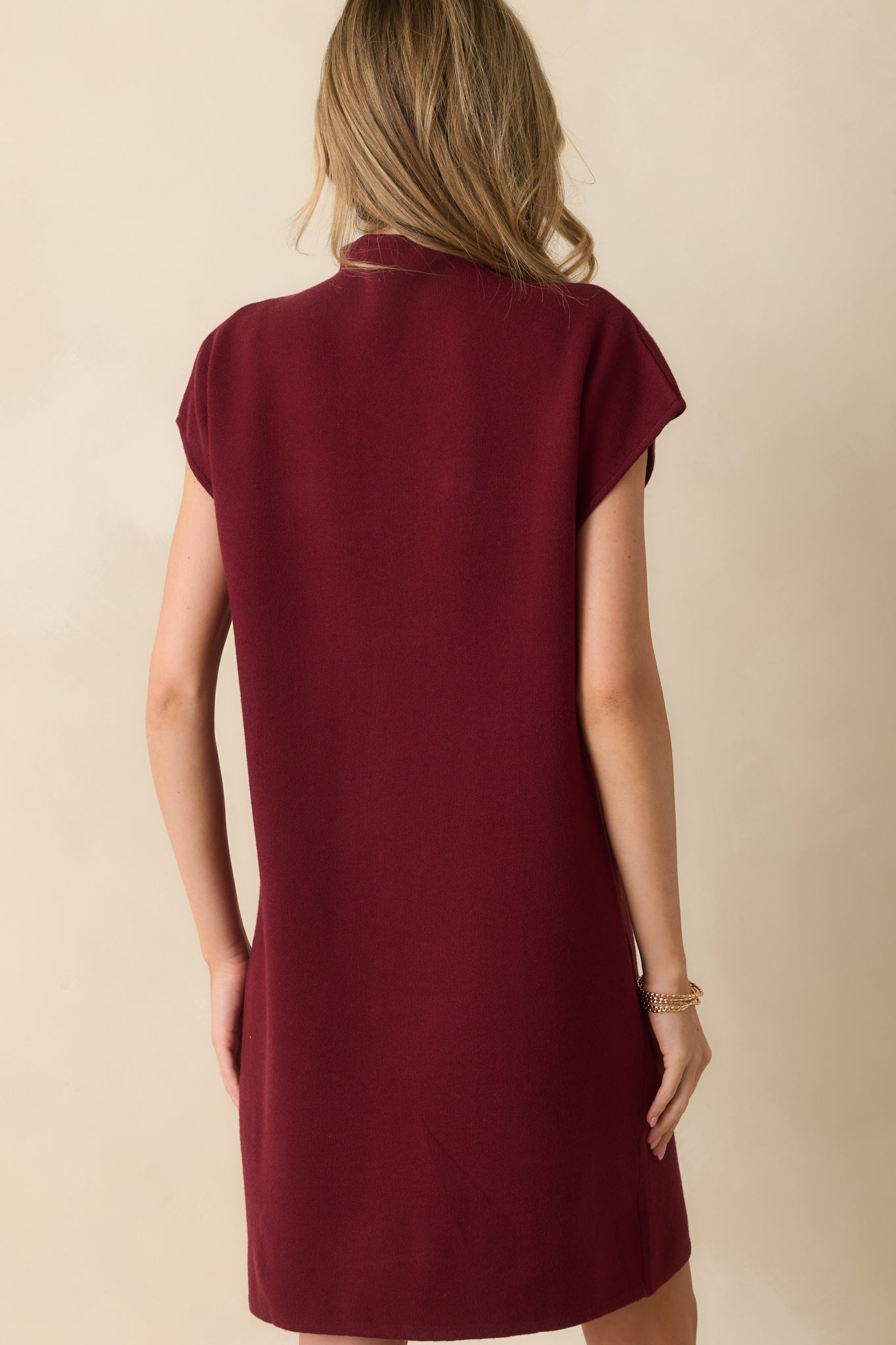 Rear view of the burgundy mini dress, showing the relaxed silhouette, ribbed texture, and mock neckline.