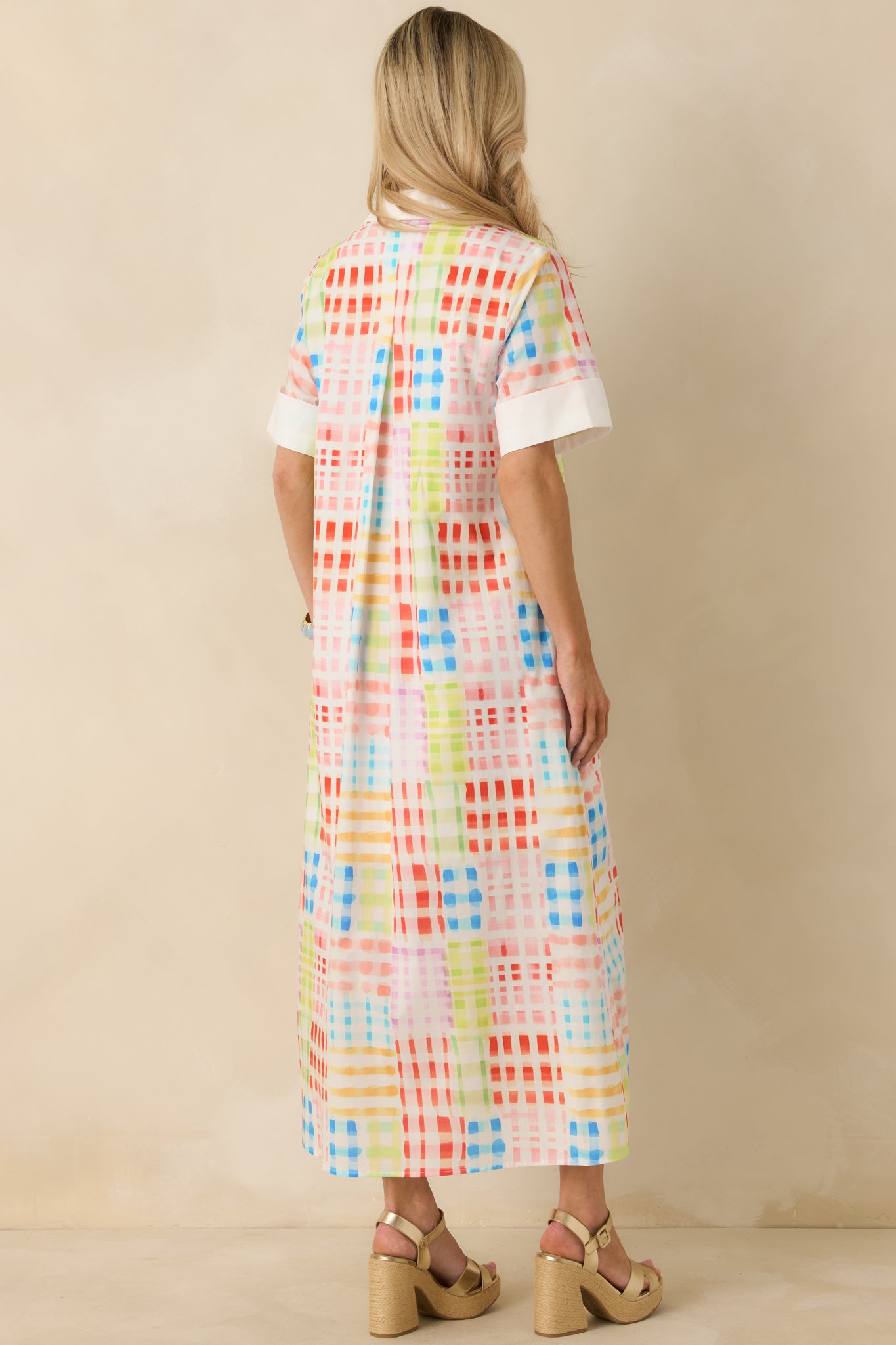 Rear view of check-patterned maxi dress showing straight fit and flowing maxi-length hem.