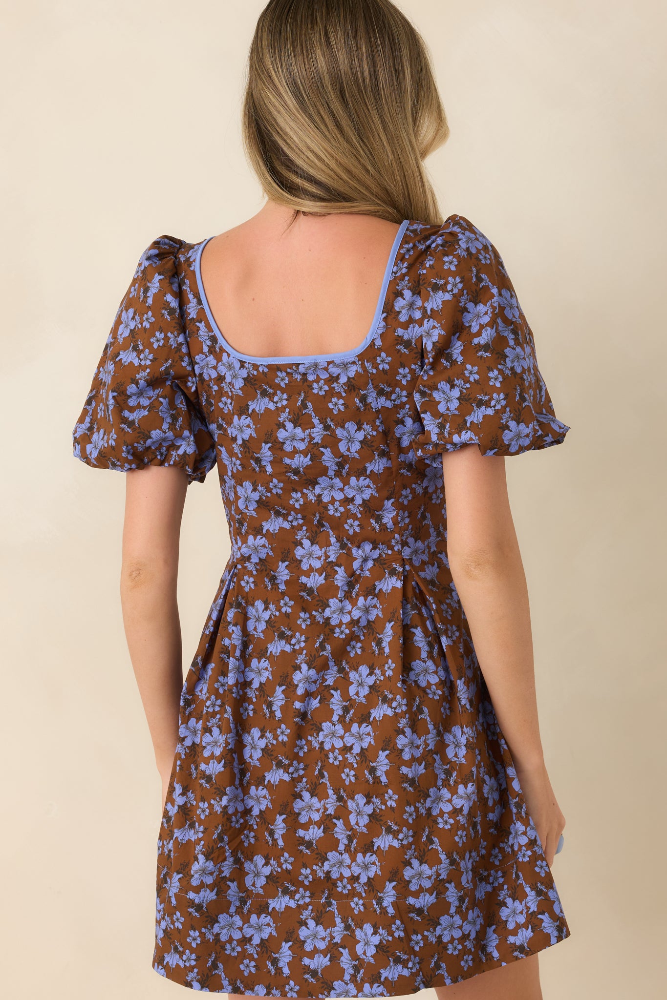 Rear view of the cotton mini dress highlighting the puff sleeves, softly flared silhouette, and clean back design.