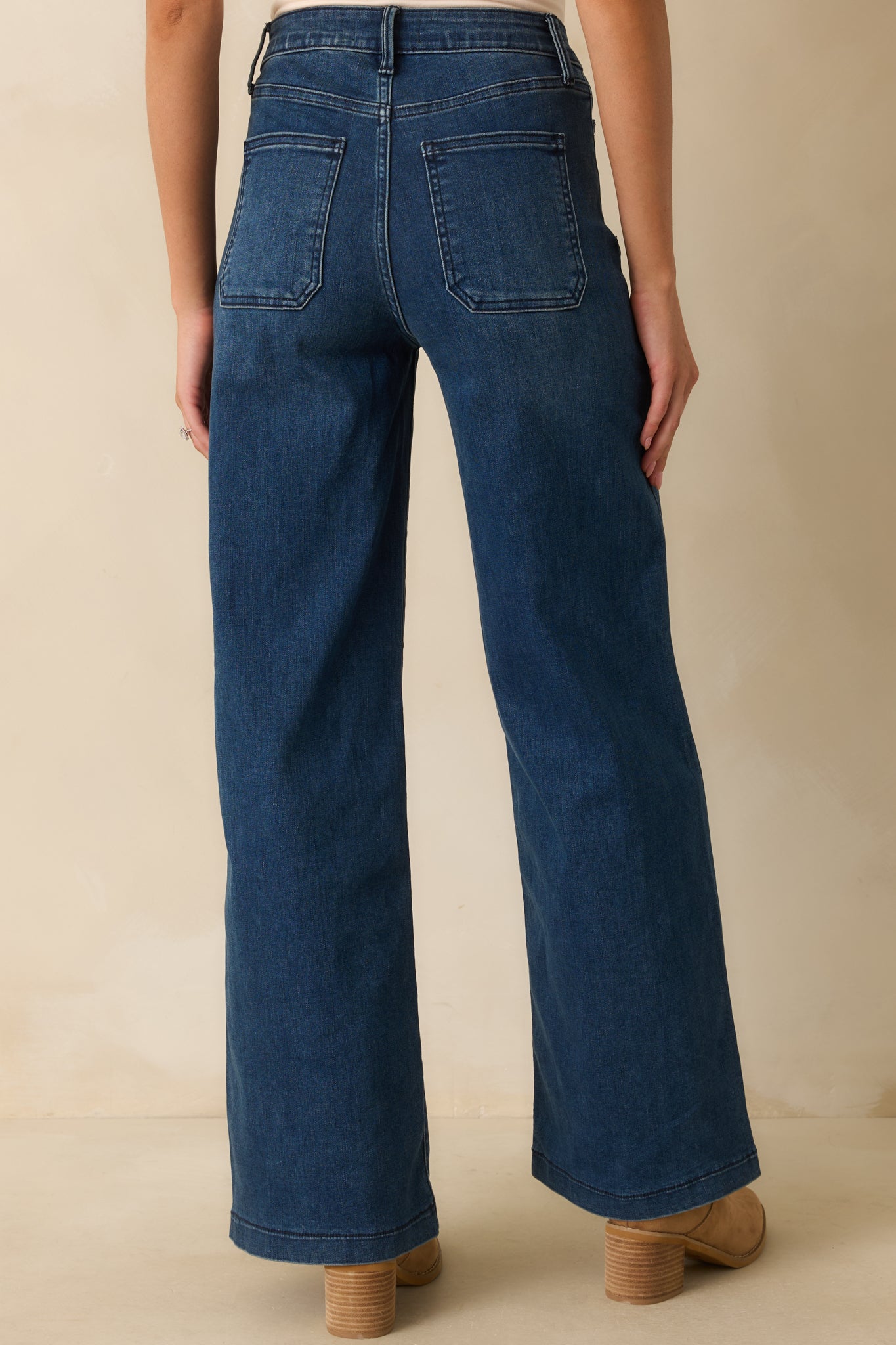 Rear view of dark wash jeans featuring functional back pockets and straight-leg silhouette