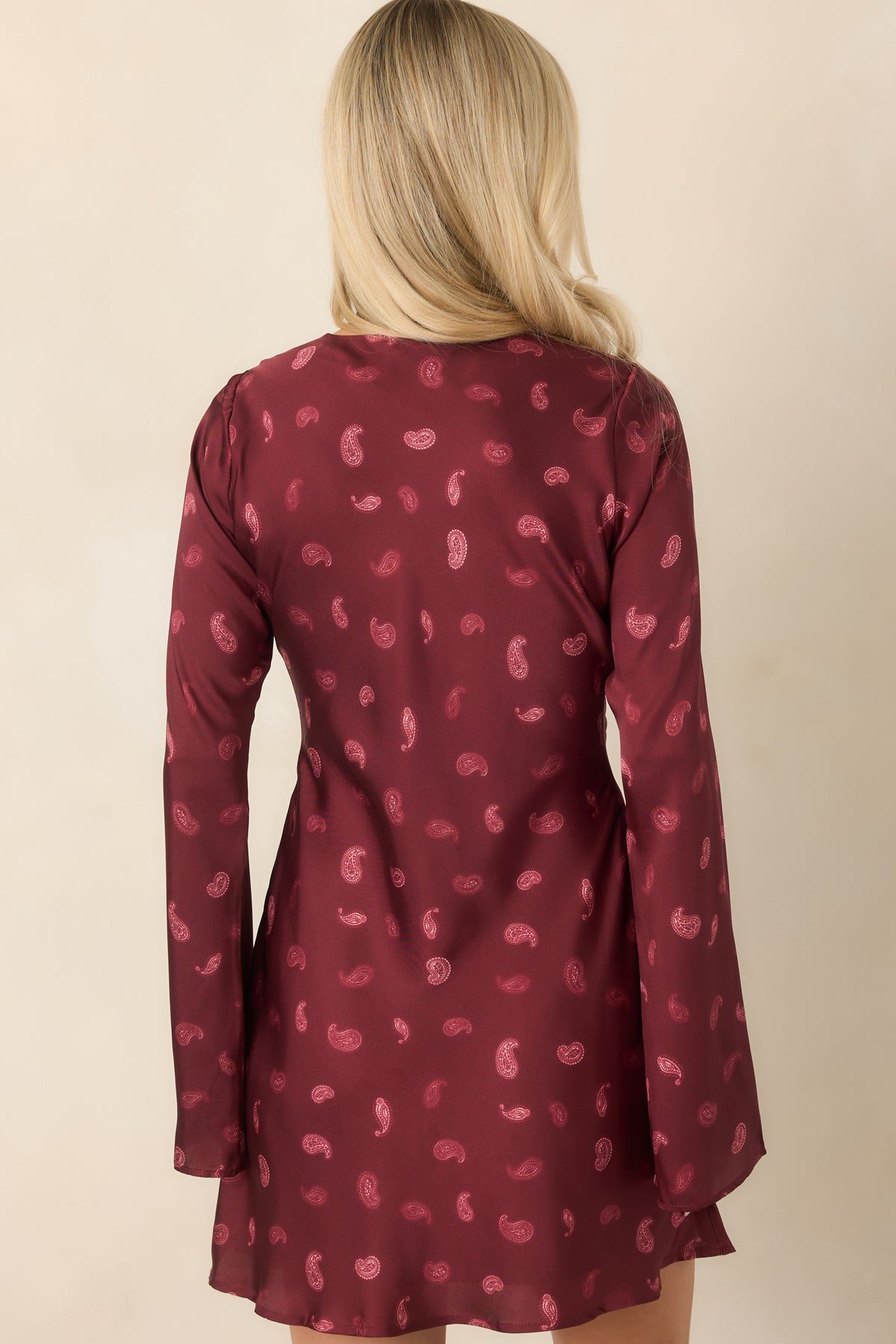 Rear view of the deep wine satin mini dress with a fluid bias-cut silhouette.