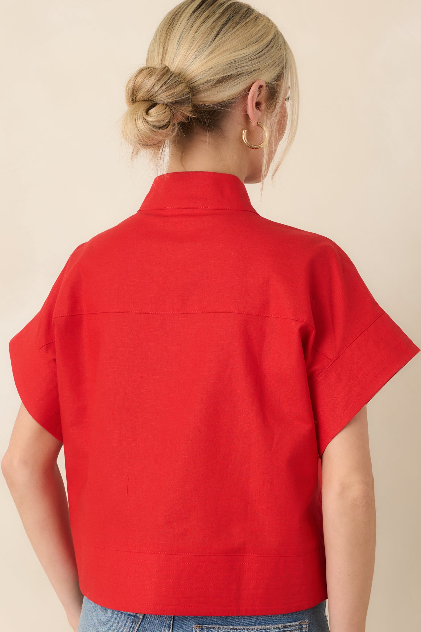 Rear view of red top displaying short sleeves, straight hem, and structured boxy fit.