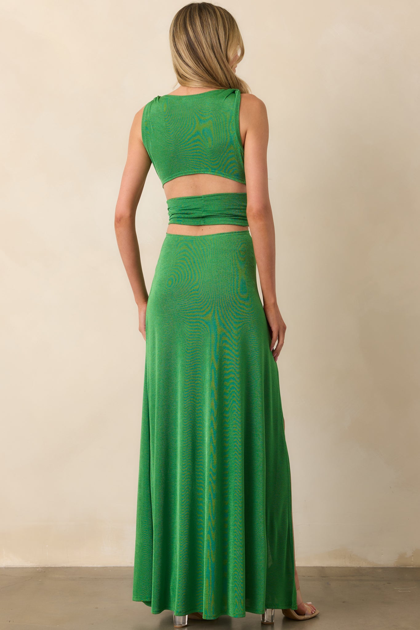 Rear view of the dress displaying the paneled back construction and the continuous flow of the shimmery green fabric to the hem.

