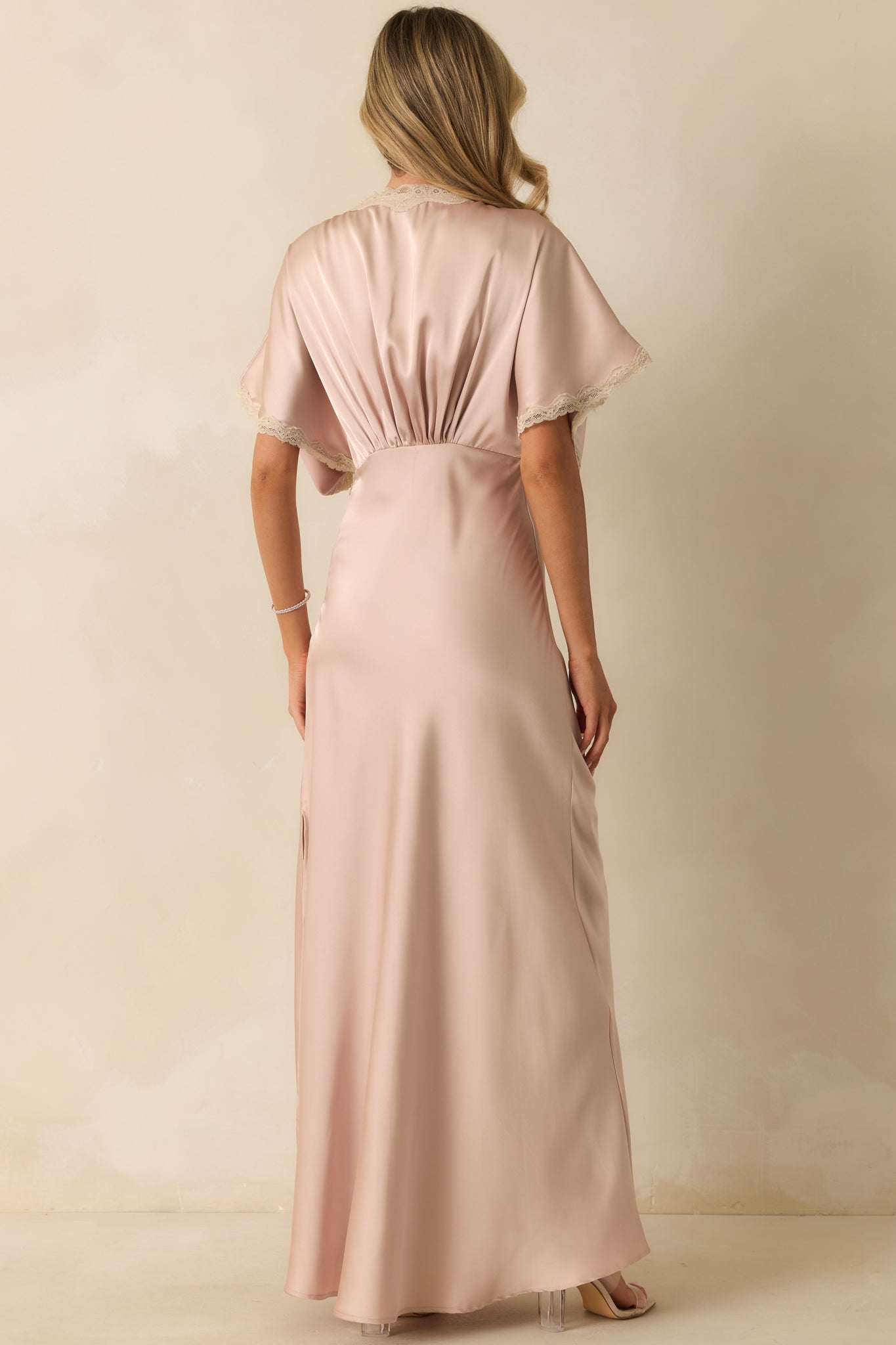 Rear view of the dusty pink satin maxi dress featuring a hidden side zipper closure and flowing skirt.