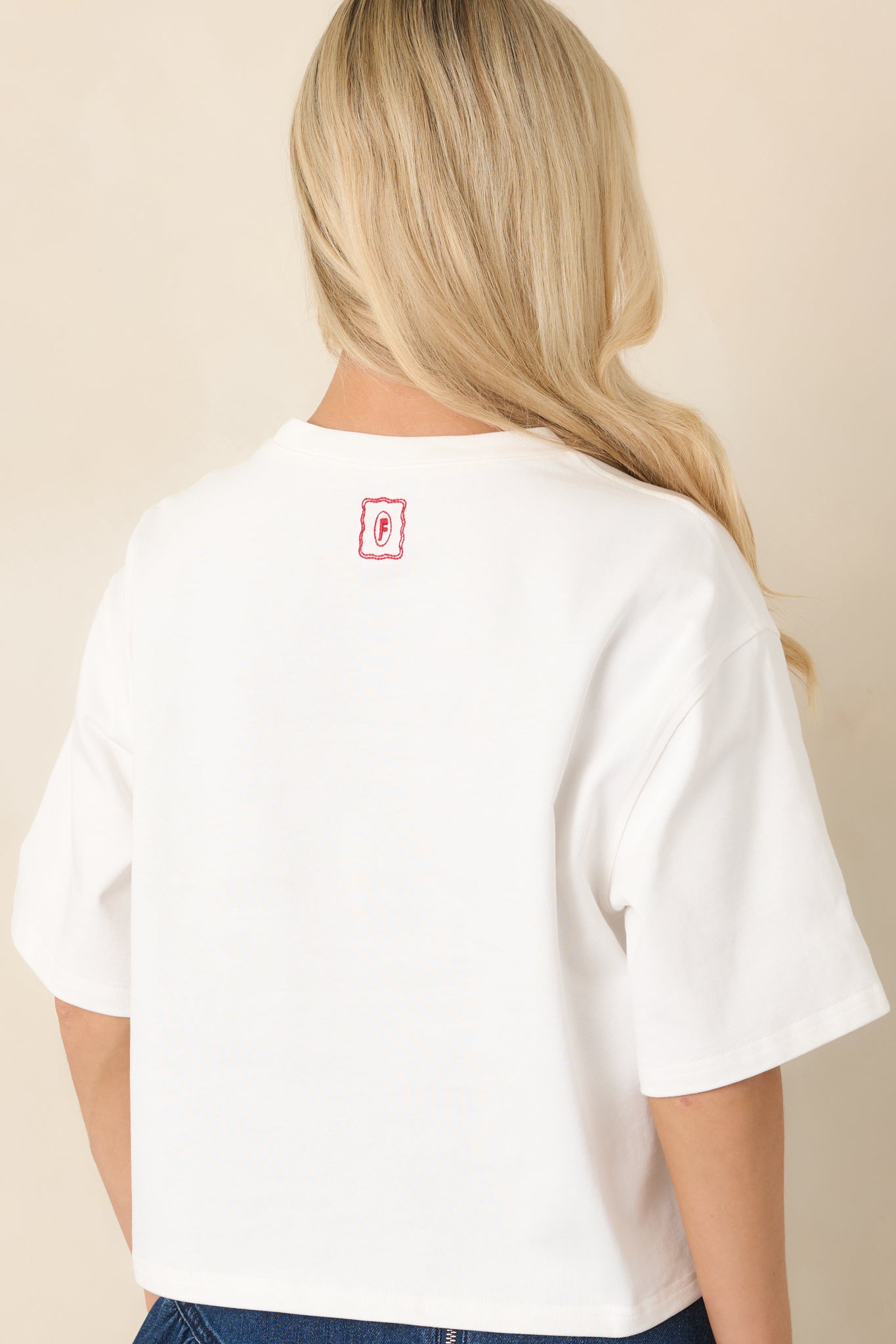 Rear view of the relaxed boxy top showcasing the short sleeves, crew neckline, and small embroidered FRNCH detail.