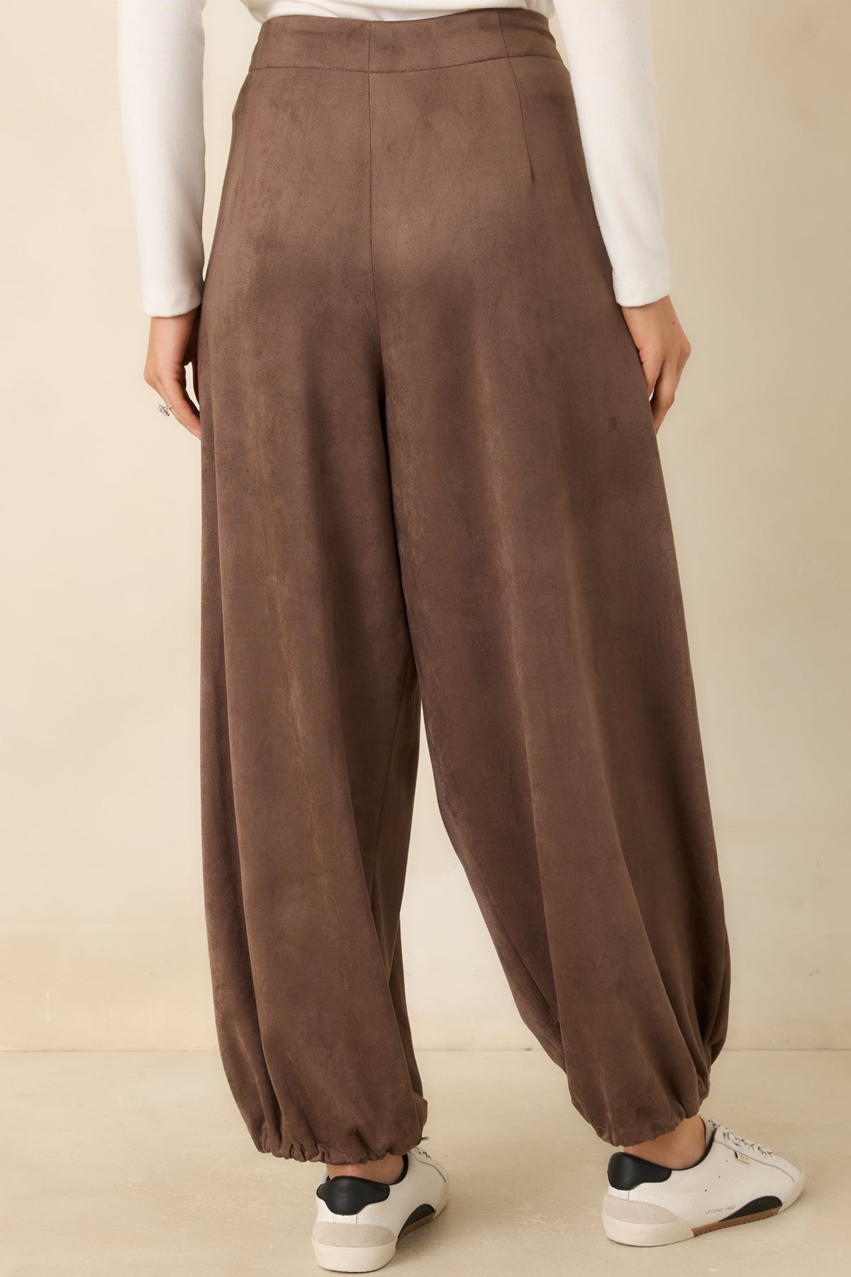 Rear view of the faux suede balloon pants showing the smooth waistband and rounded legs.