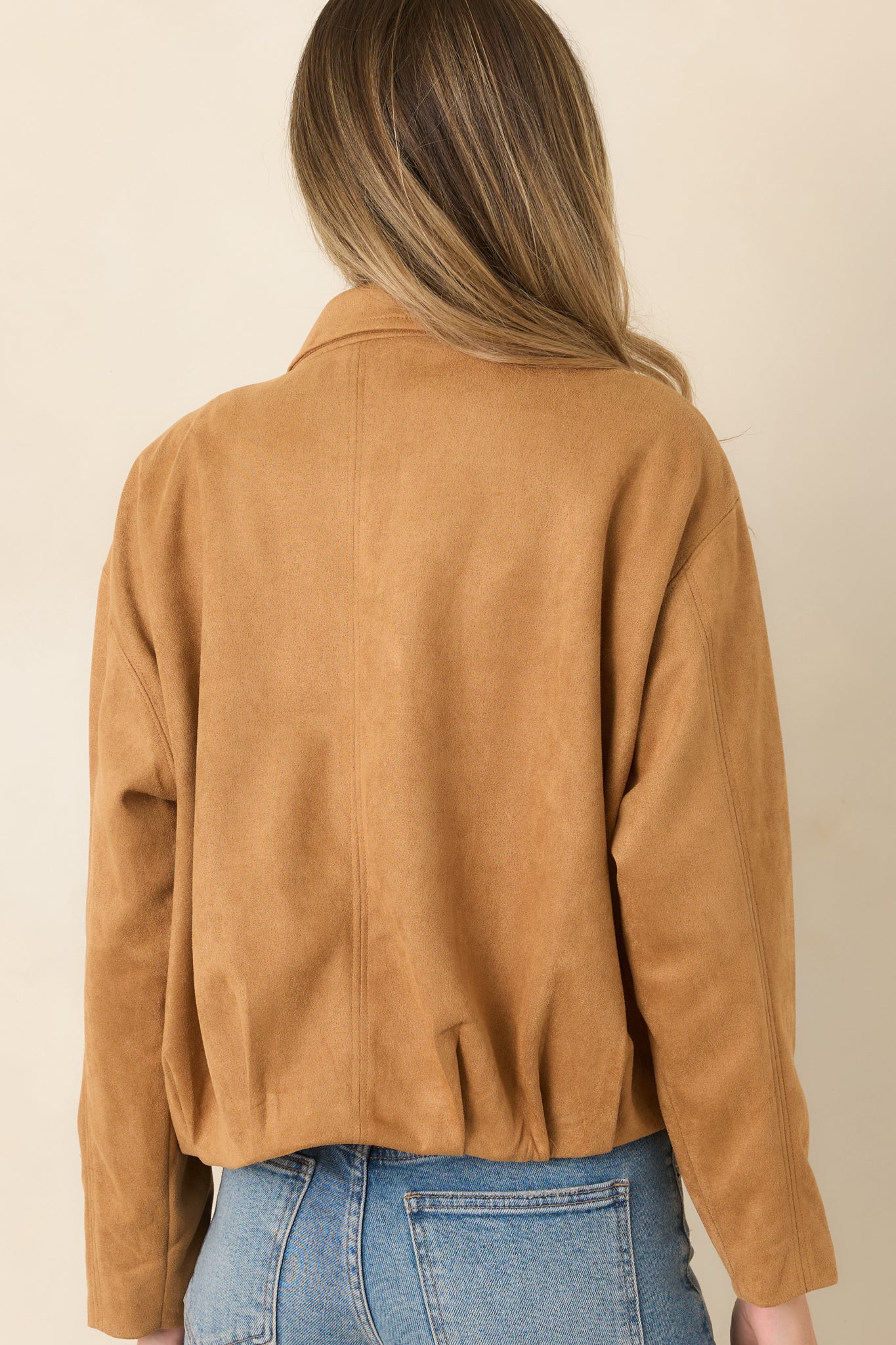 Rear view of the faux suede jacket showcasing the relaxed blouson silhouette, dropped shoulders, gathered hem, and clean back design.