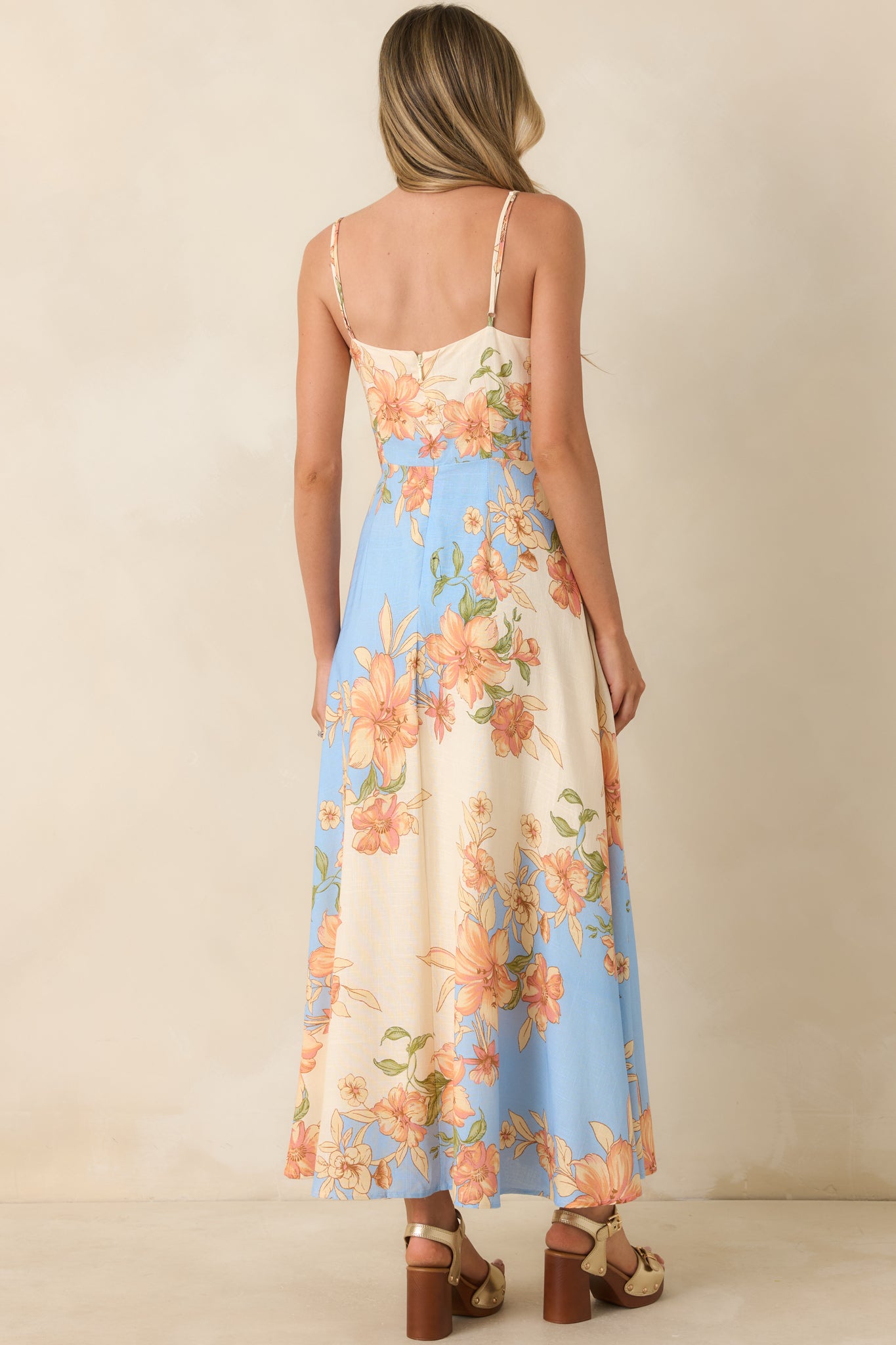 Rear view of the floral maxi dress featuring delicate adjustable straps, a fitted bodice continuation, and smooth flowing skirt.