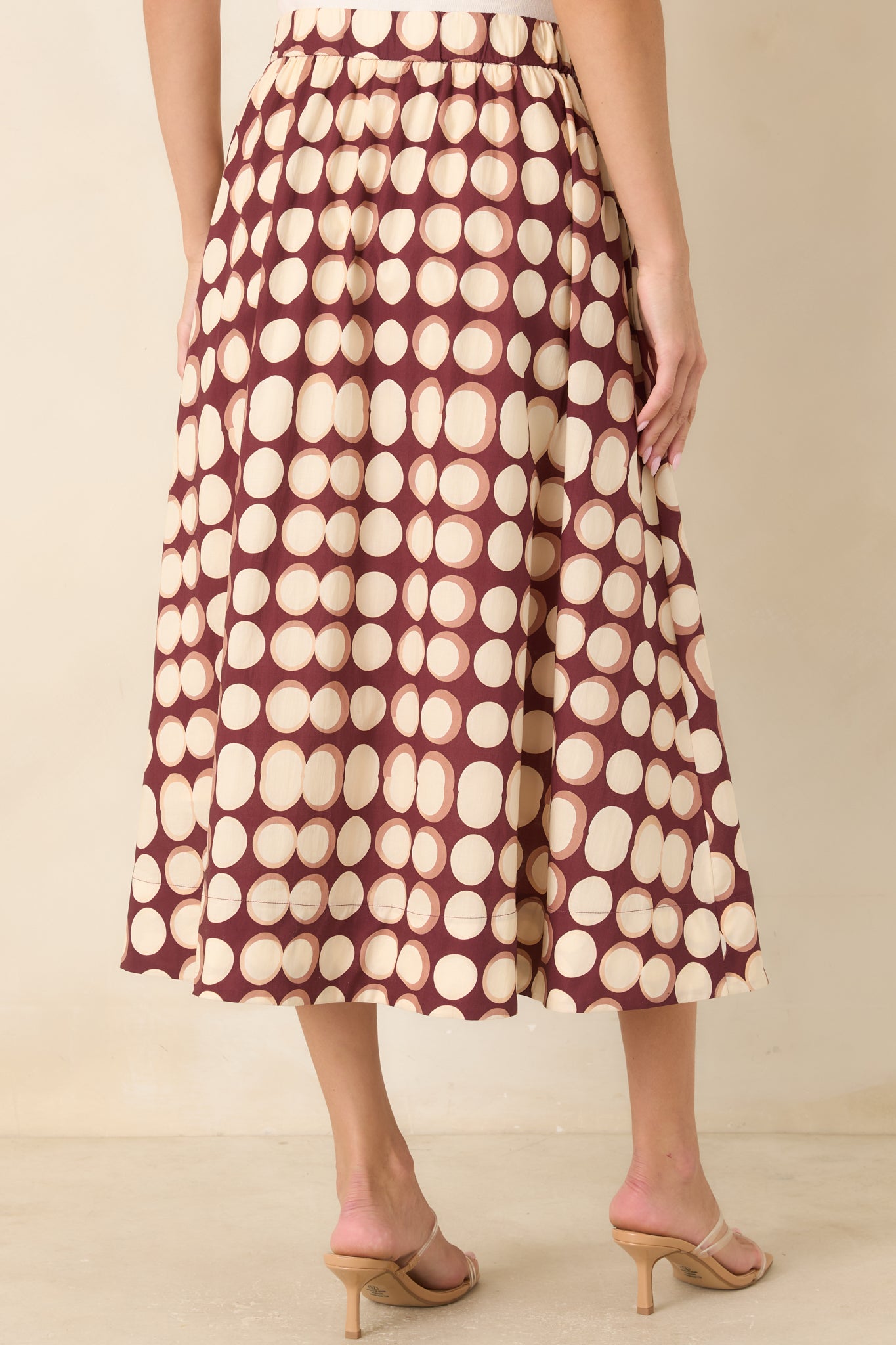 Rear view of the cotton skirt showcasing the elasticized back waistband, gathered fabric, and full A-line silhouette.