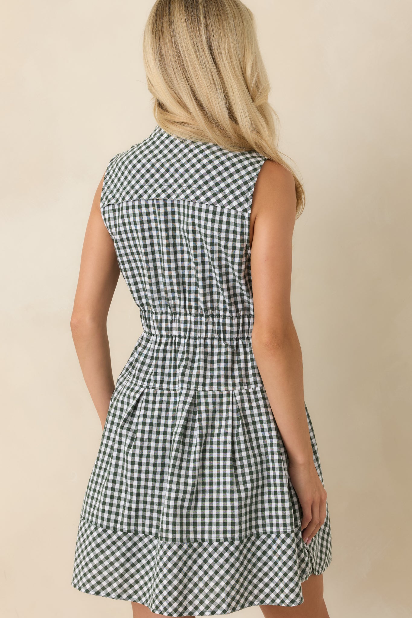 Rear view of the gingham mini dress featuring a relaxed silhouette, elastic waistband, lined construction, and clean finished hem.