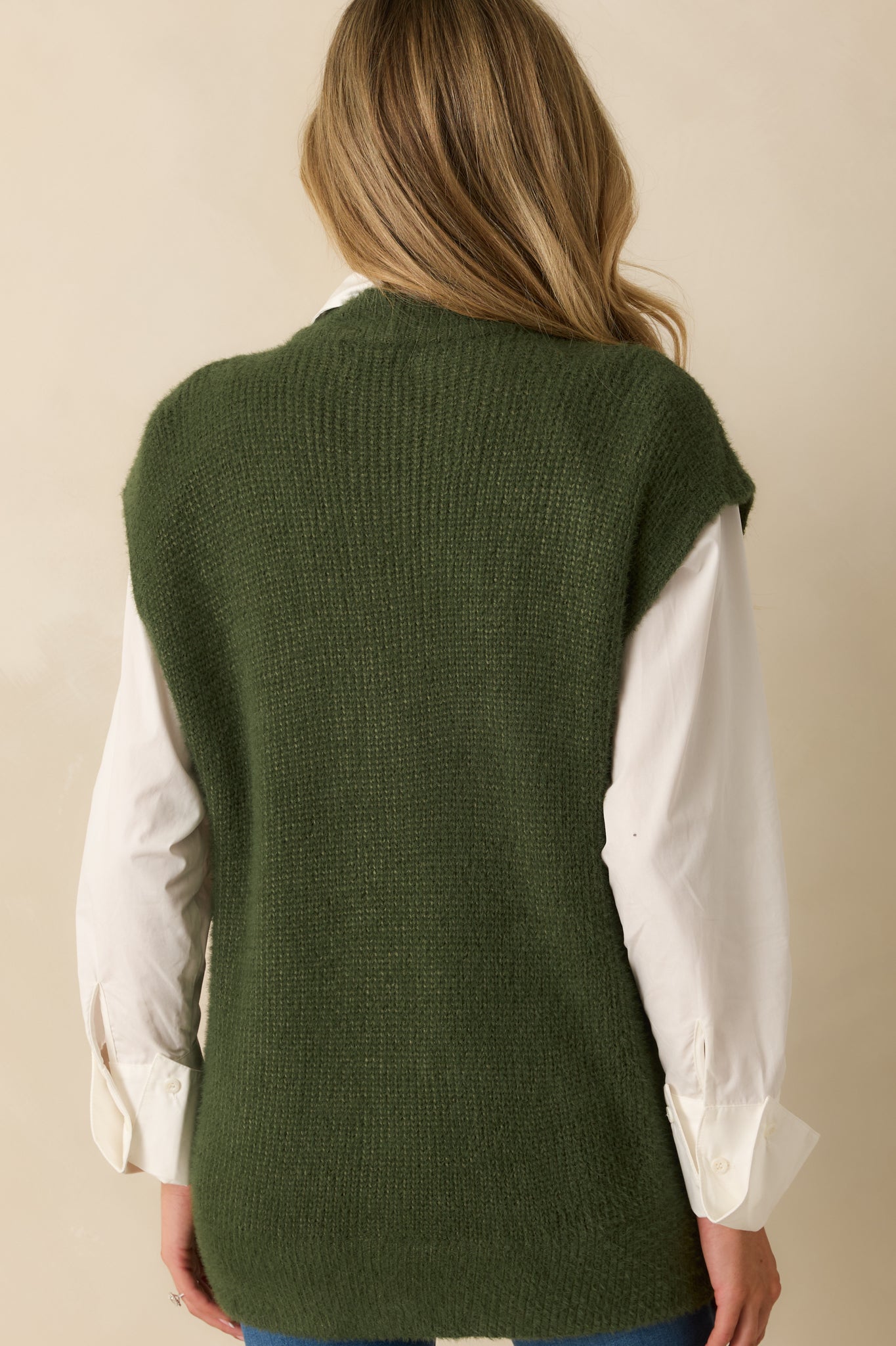 Rear view of the green knit cardigan displaying the smooth back and relaxed silhouette.