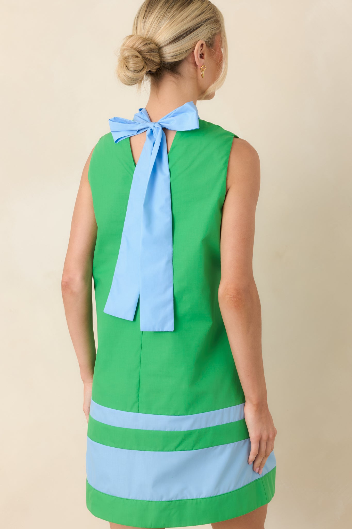 Rear view of the mini dress highlighting the bow-tie closure, keyhole detail, and the clean, sleeveless shift silhouette.