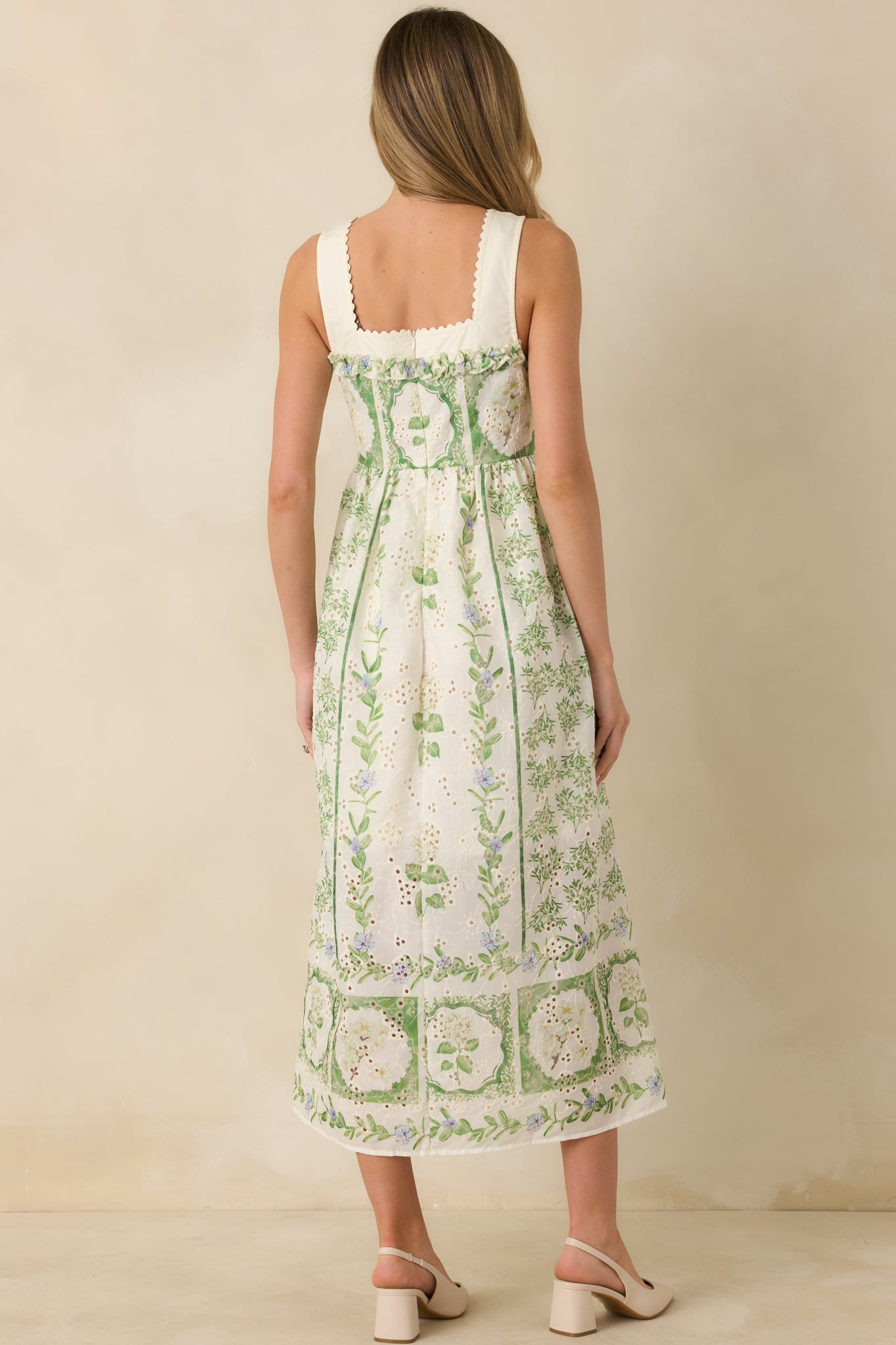 Rear view of the ivory and green floral maxi dress highlighting the concealed zipper closure and the smooth drape of the lined skirt.

