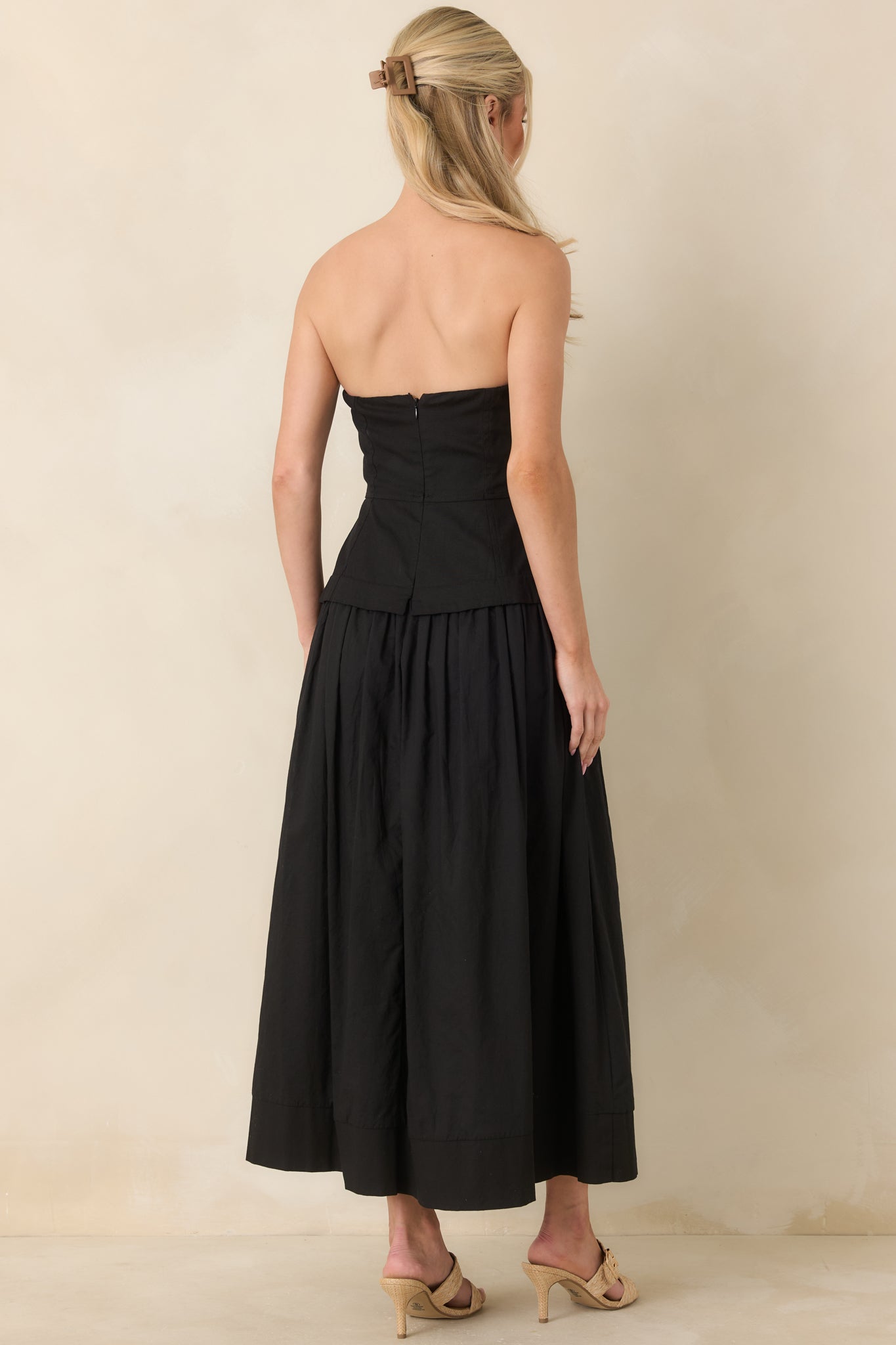Rear view highlighting the concealed zipper closure, structured bodice, and flowy skirt silhouette.