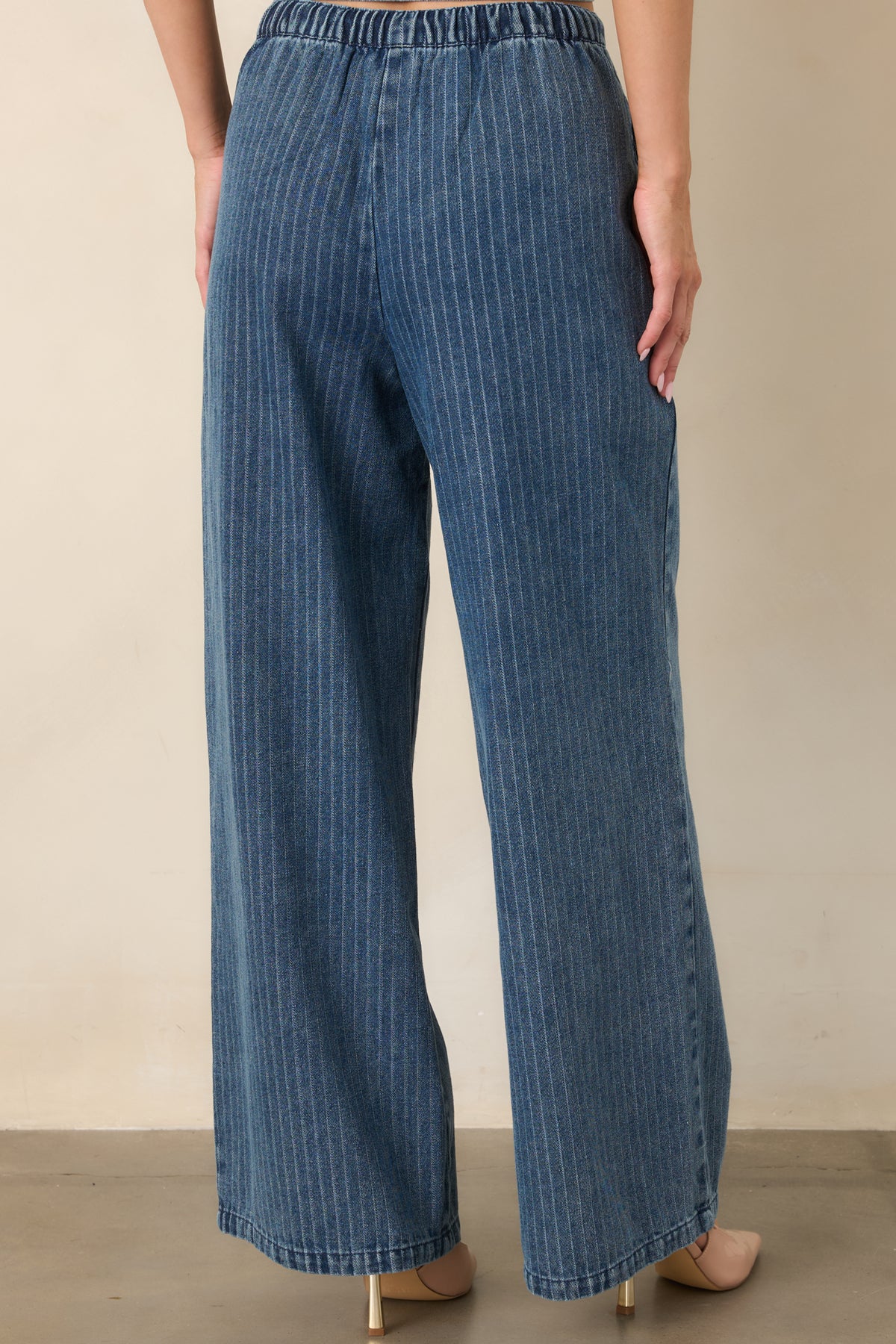Rear view of the indigo striped pants showcasing the elastic waistband, adjustable drawstring, wide-leg silhouette, and soft denim construction.