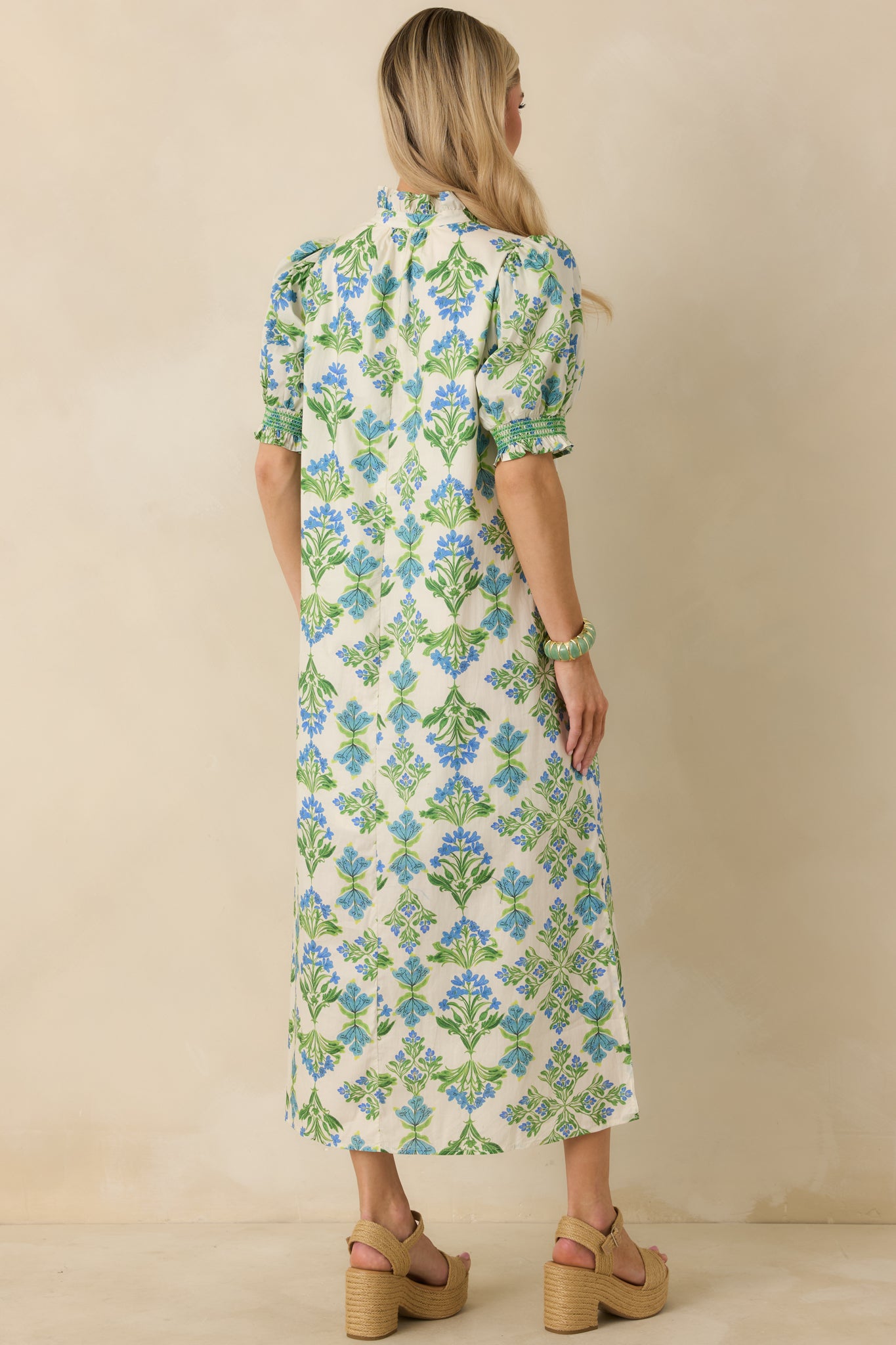 Rear view of the ivory floral maxi dress highlighting the straight silhouette, side slit, and fluid cotton drape.