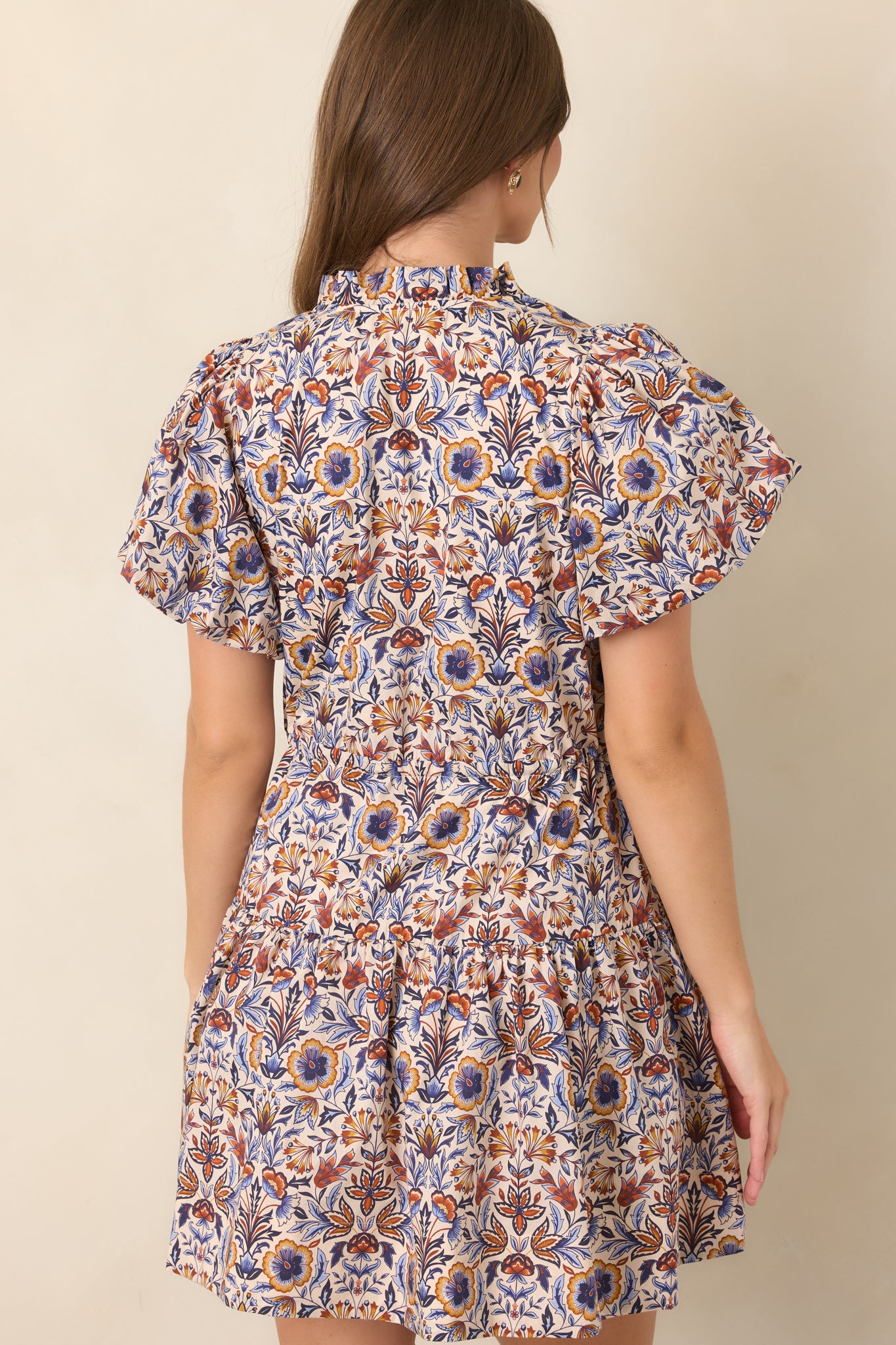 Rear view of the floral mini dress featuring the adjustable drawstring waist, softly tiered skirt, and colorful print.