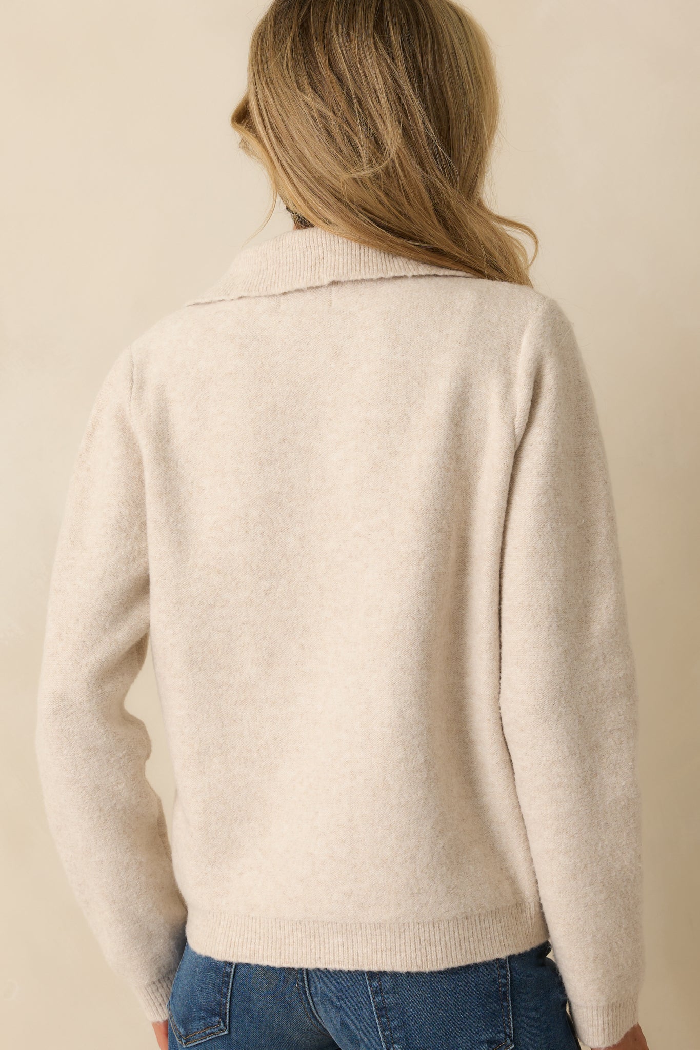 Rear view of the ivory knit cardigan showing long sleeves and relaxed fit.
