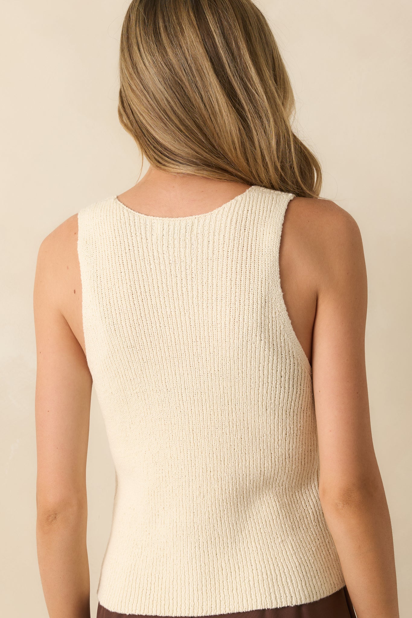 Rear view of the ivory sweater vest showing sleeveless design and lightweight knit fabric.