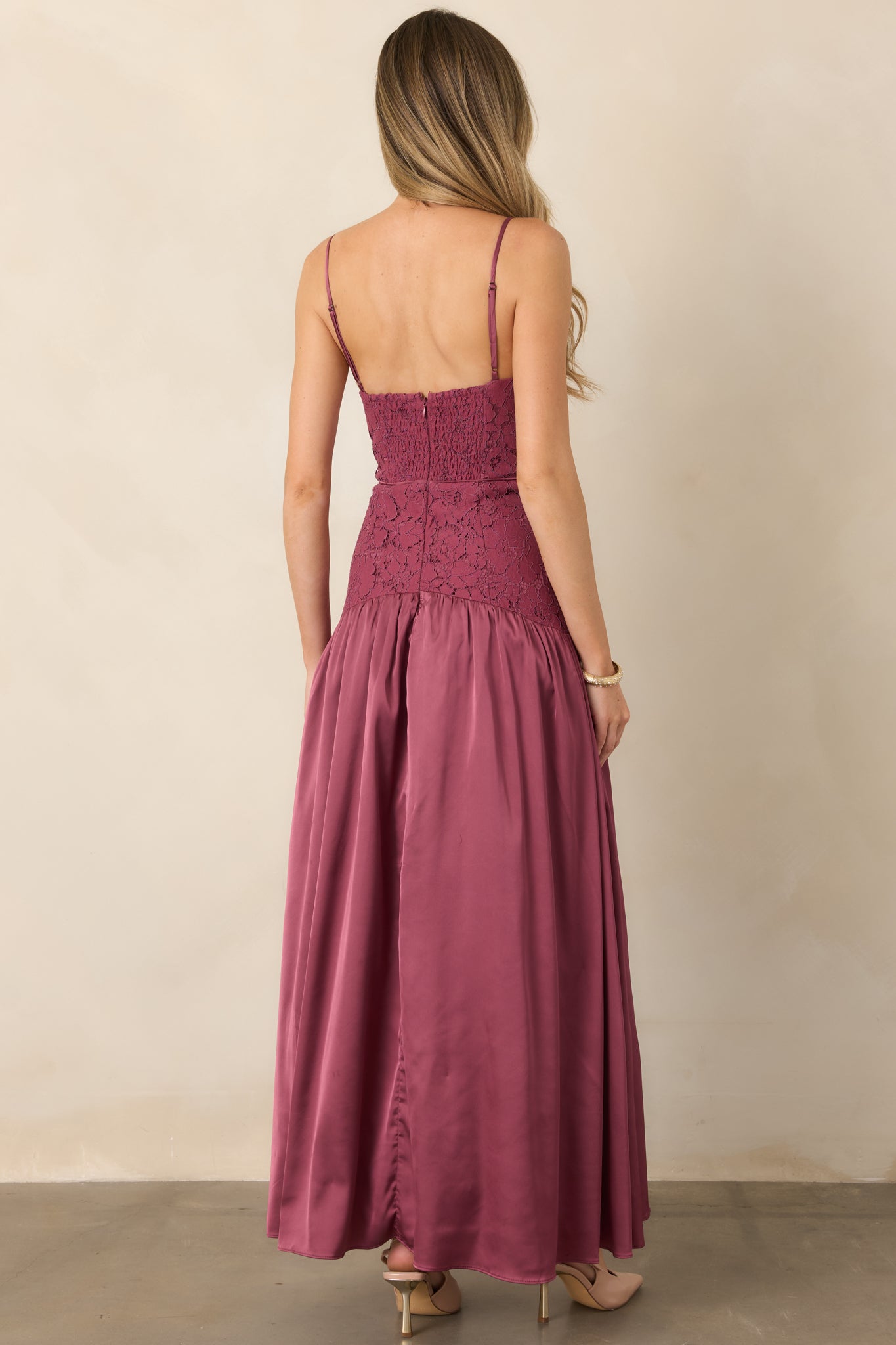 Rear view of the lace and satin maxi dress showcasing the partially smocked back, center-back zipper, dropped waist, and gathered flowing skirt.